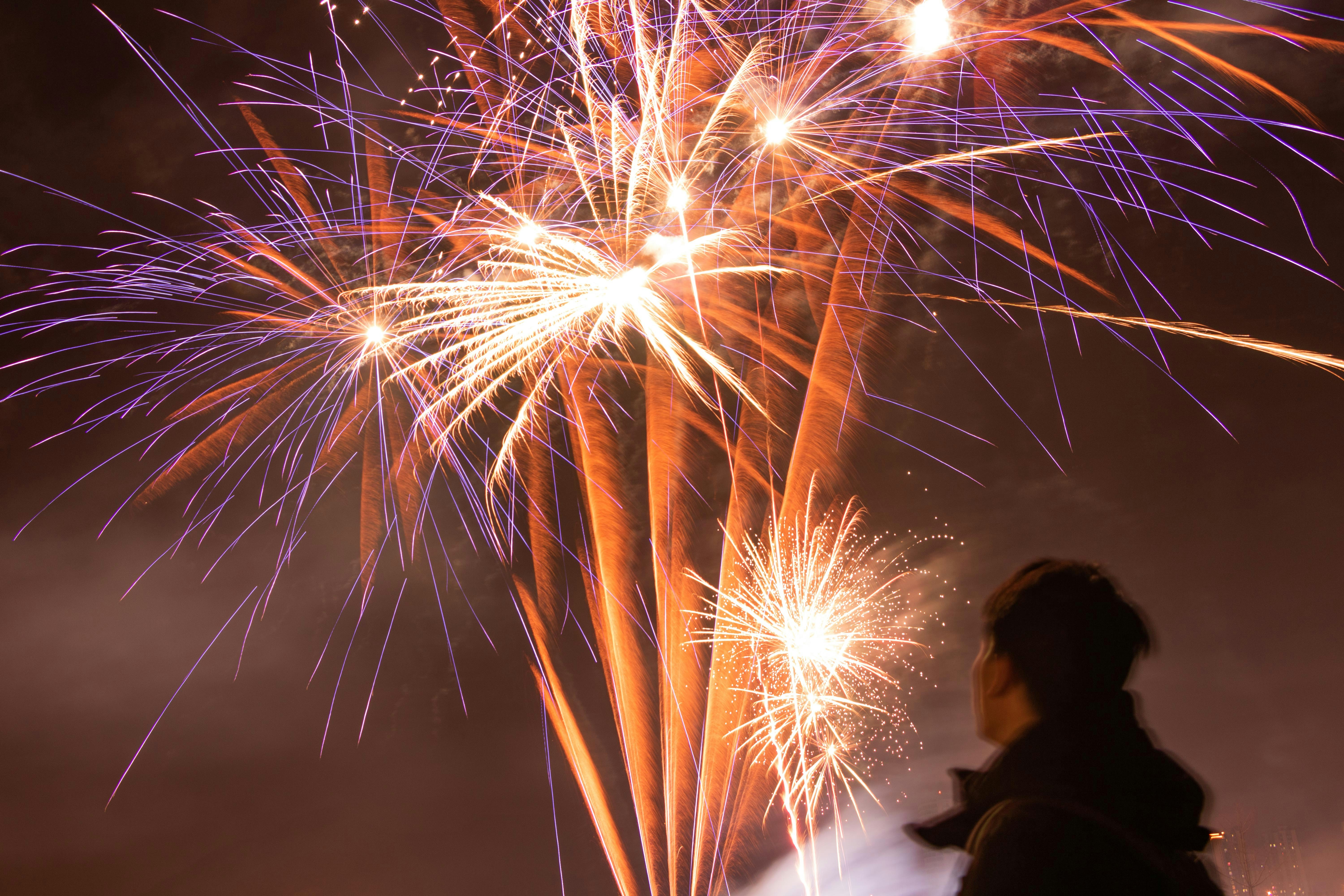 A man standing in front of a firework display photo – Free Fireworks ...
