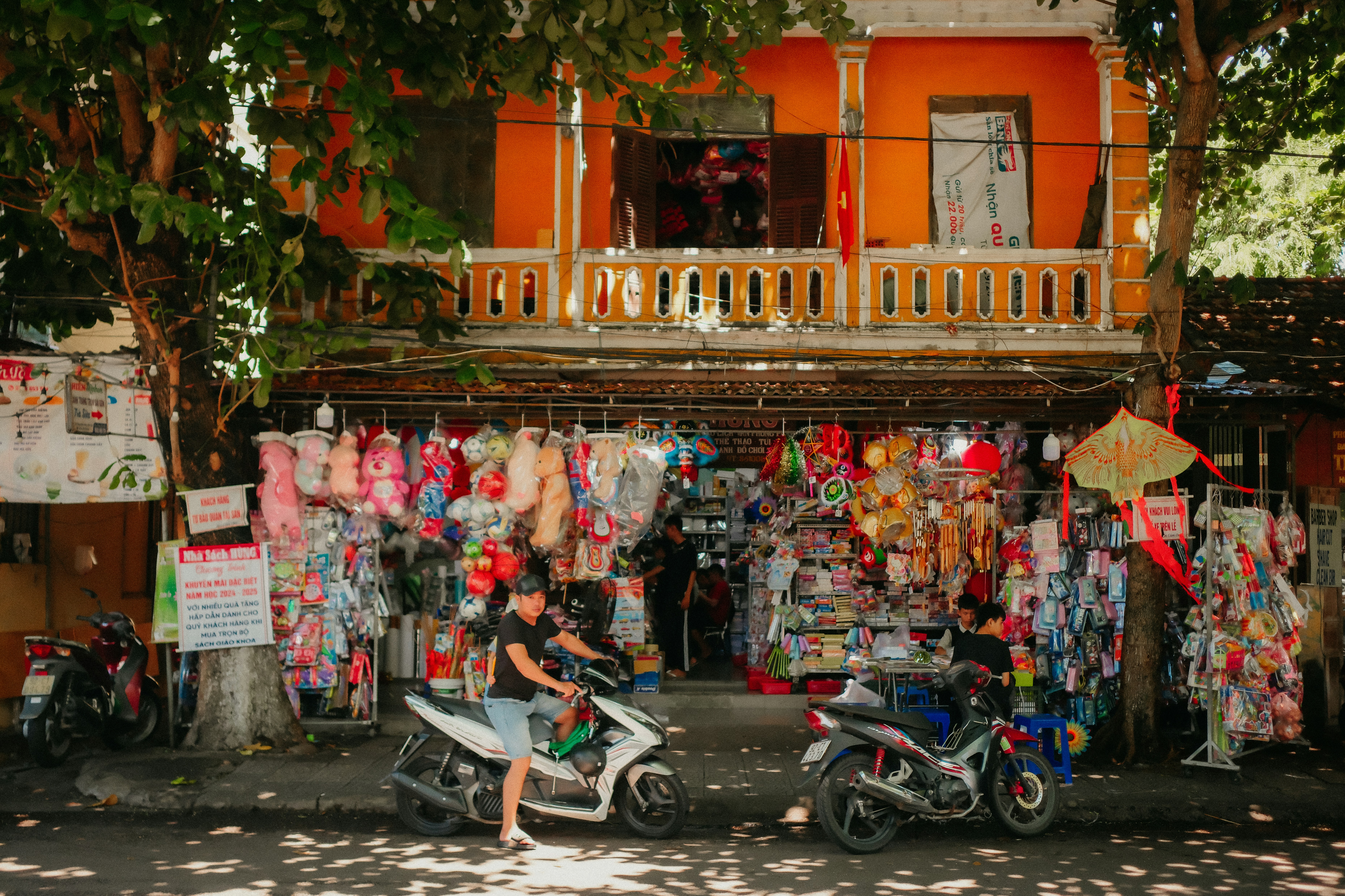 A person sitting on a scooter in front of a store