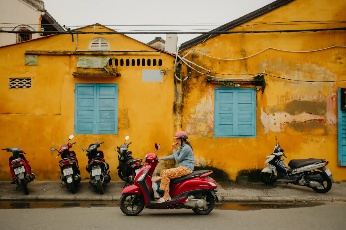 Traditional mustard-yellow heritage buildings lined with colorful lanterns in Hoi An Ancient Town