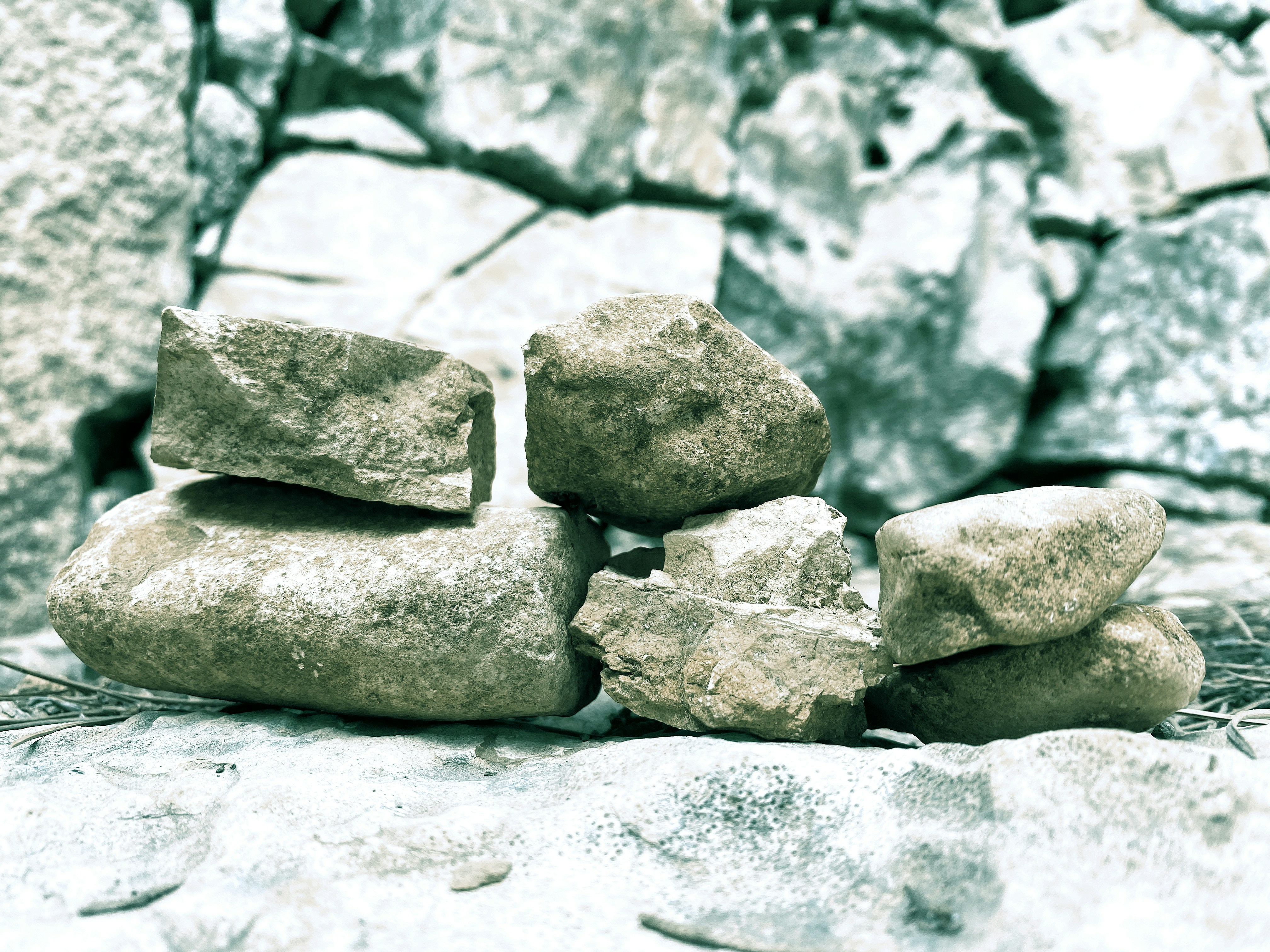 Un montón de piedras junto a un muro de piedra