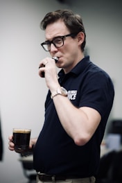 A man holding a glass of beer in his hand