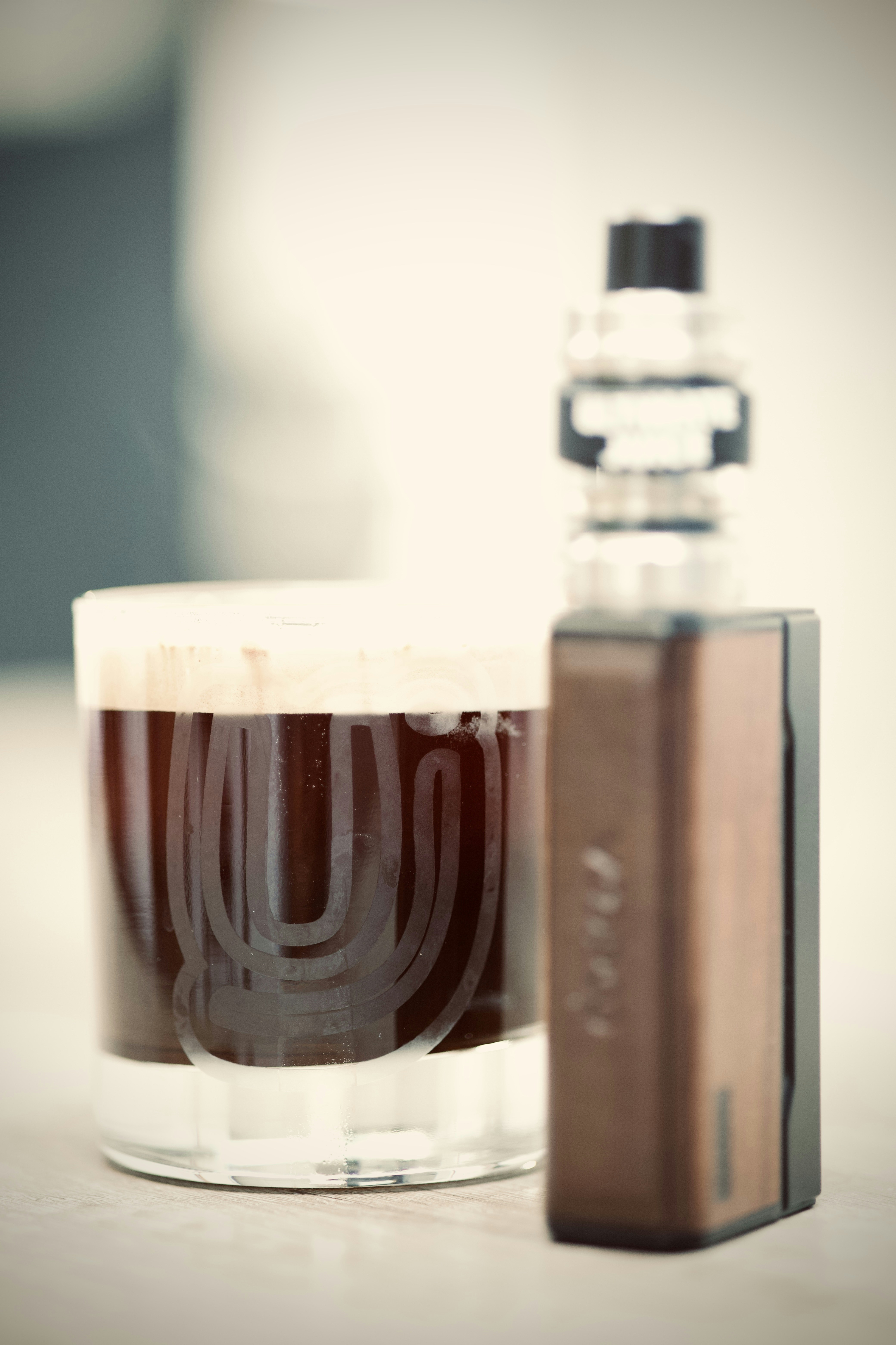 A glass of beer next to an electronic device