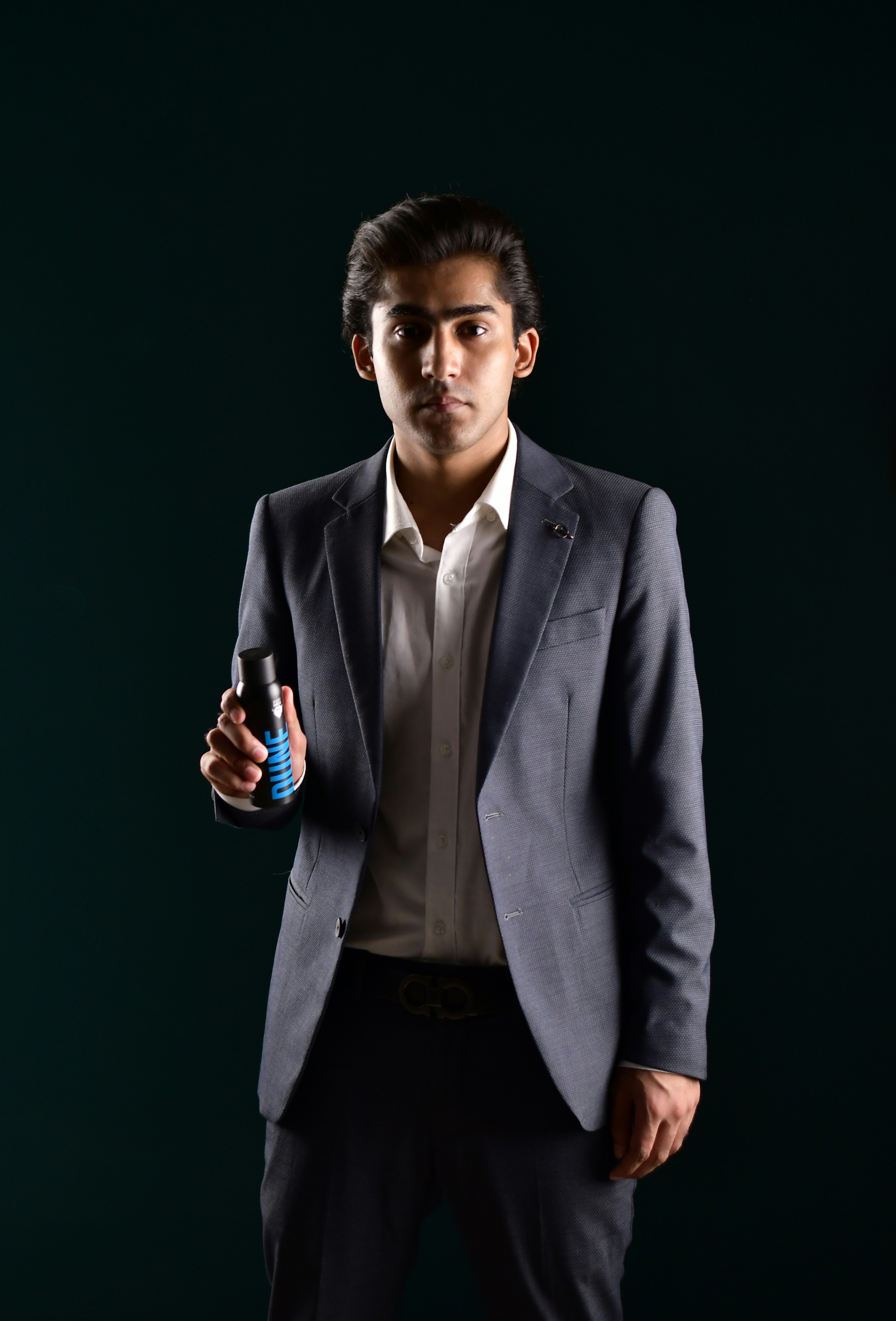 A man in a suit holding a bottle of water
