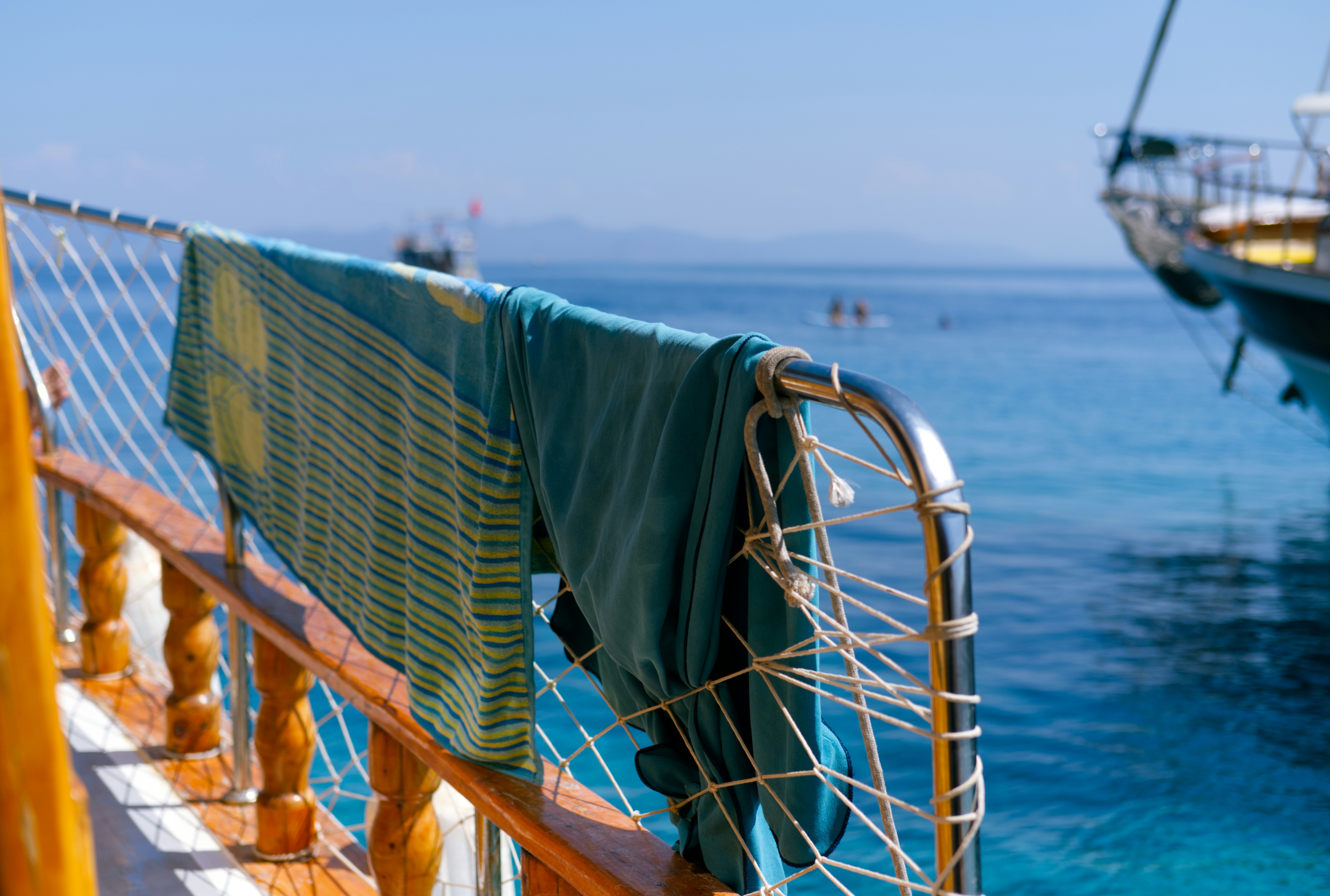 Towels hanging on the railing of a boat in the ocean