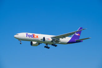 A fedex airplane flying in a clear blue sky