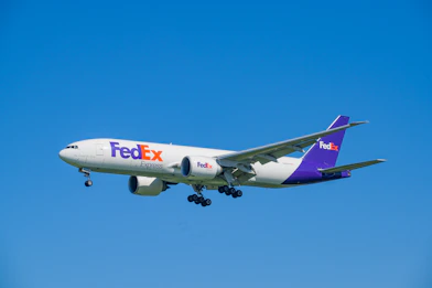 A fedex airplane flying in a clear blue sky