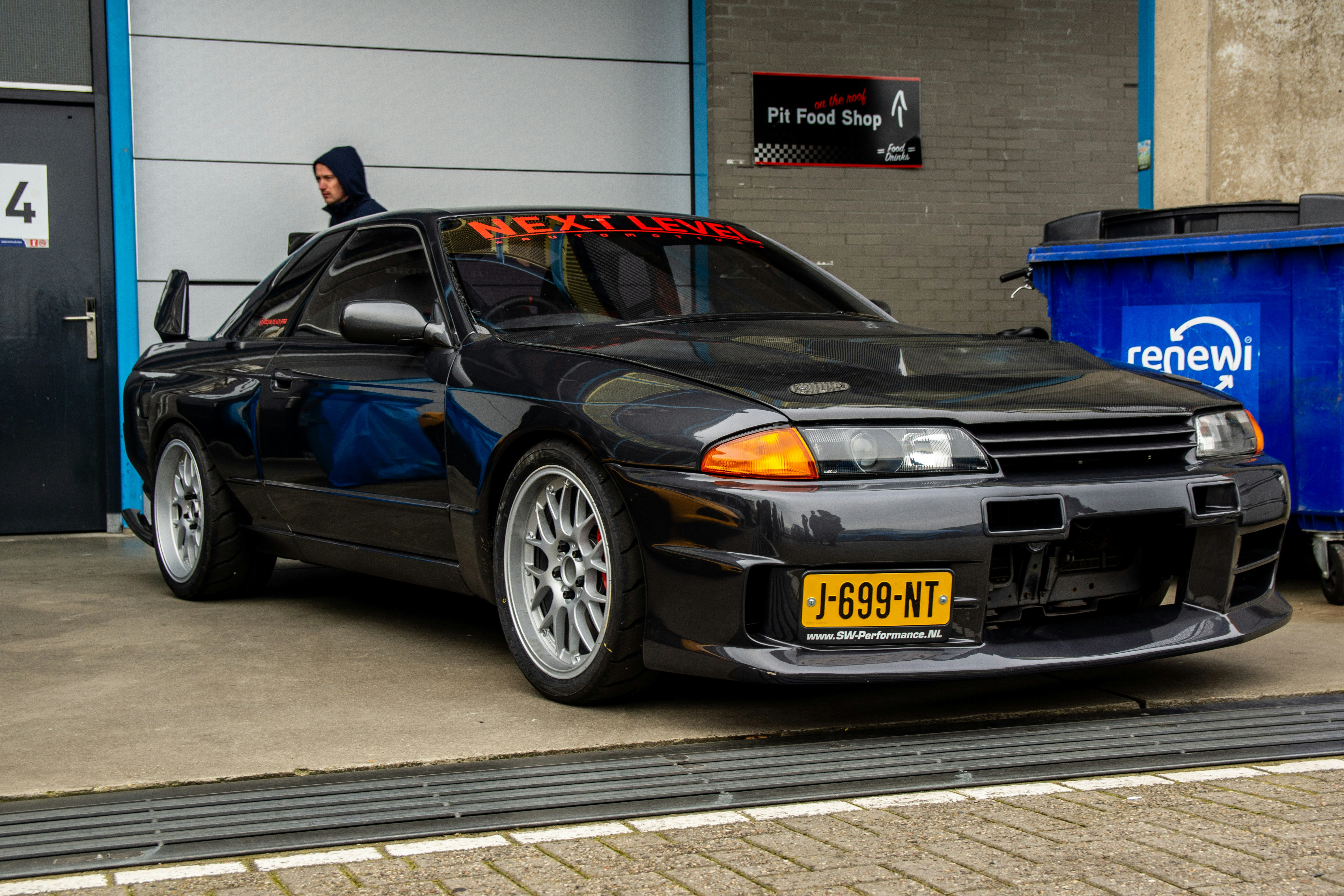 A black car parked in front of a garage