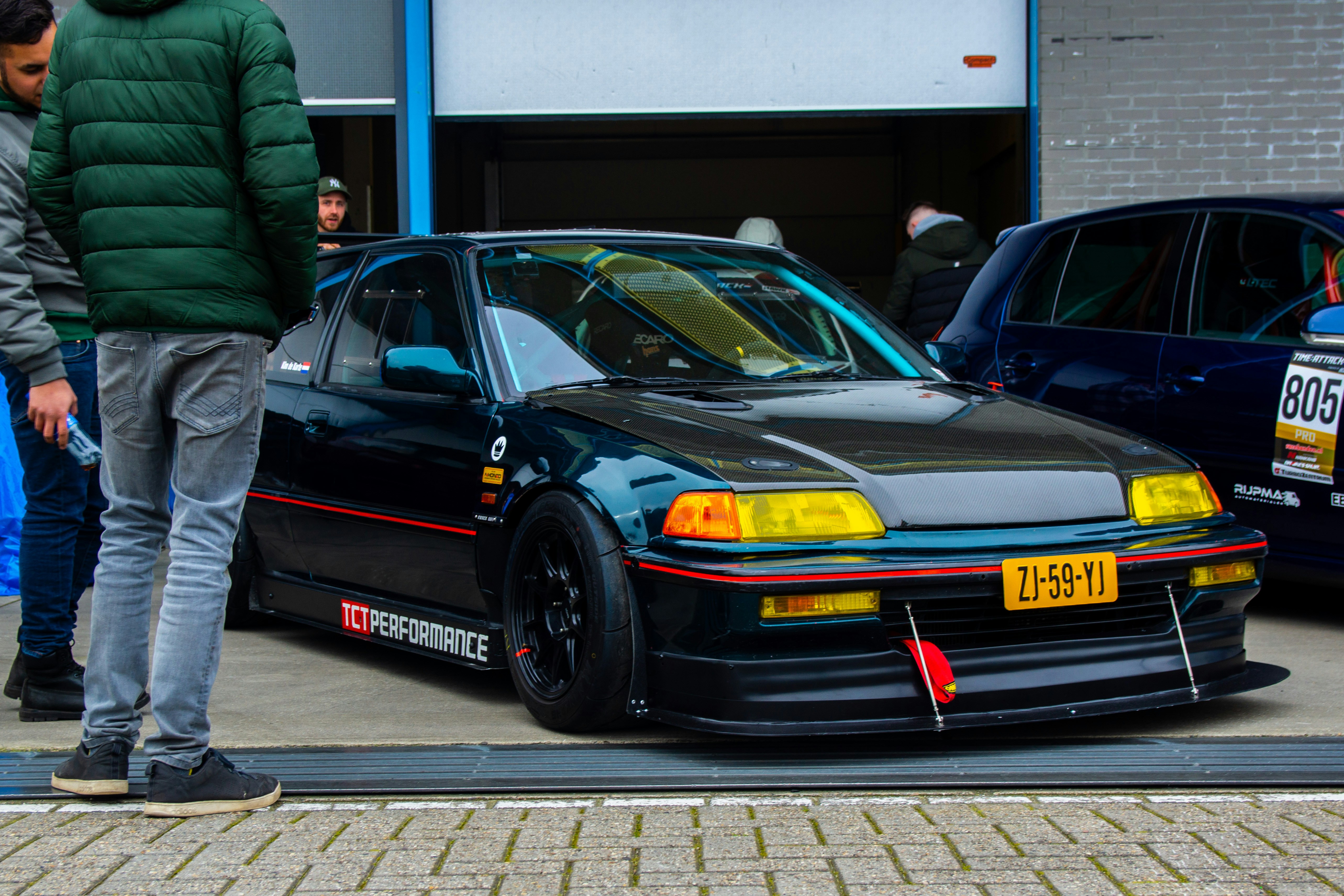 A man standing next to a car in a parking lot