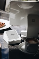 A table topped with a laptop computer next to a cup of coffee