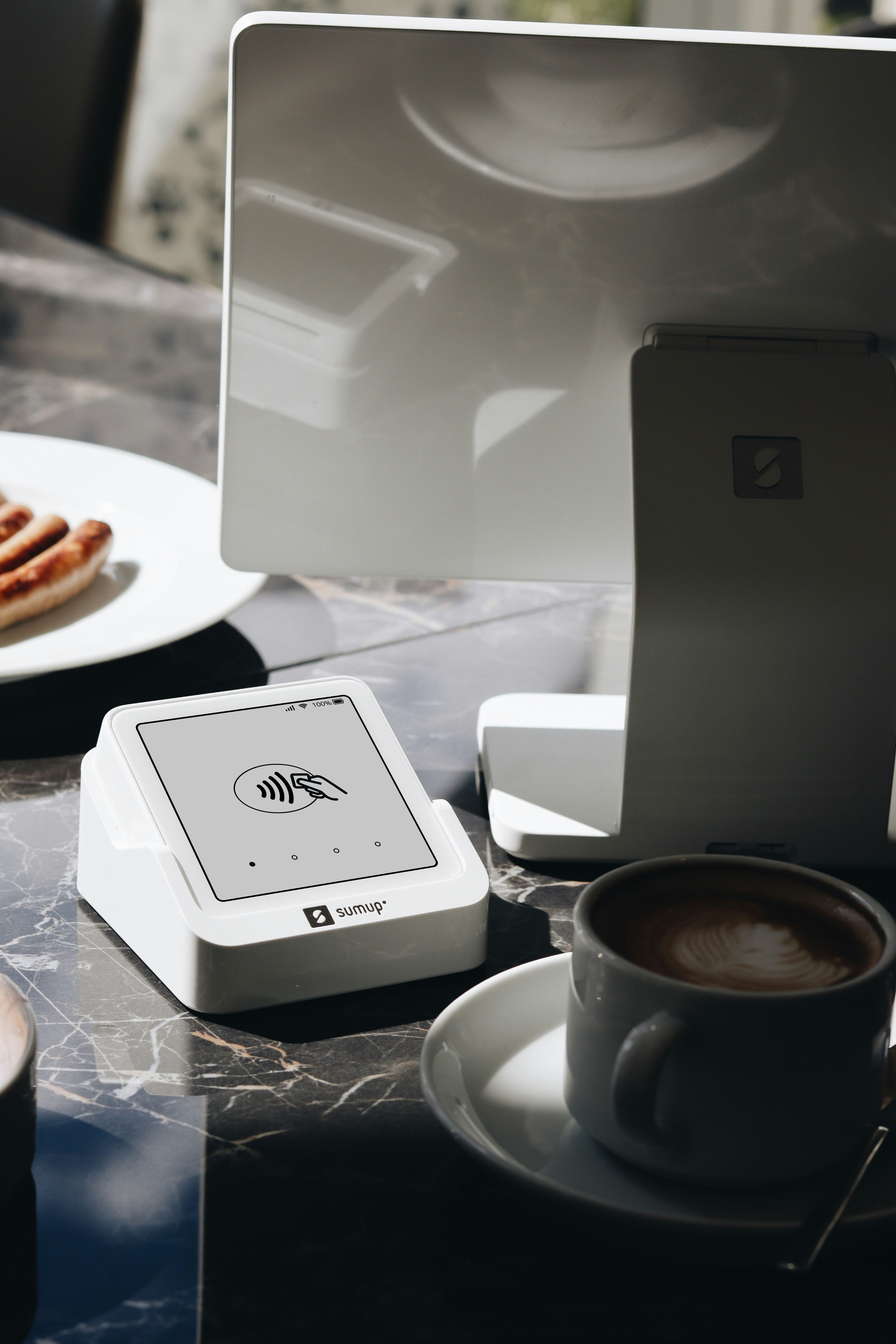 A SumUp card reader and POS lite system are shown on a restaurant table, highlighting the ease of accepting payments during meals. This solution is perfect for restaurants and small businesses that need a reliable and efficient payment system.