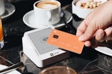 A person holding a credit card over a table