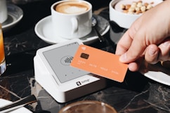 A person holding a credit card over a table