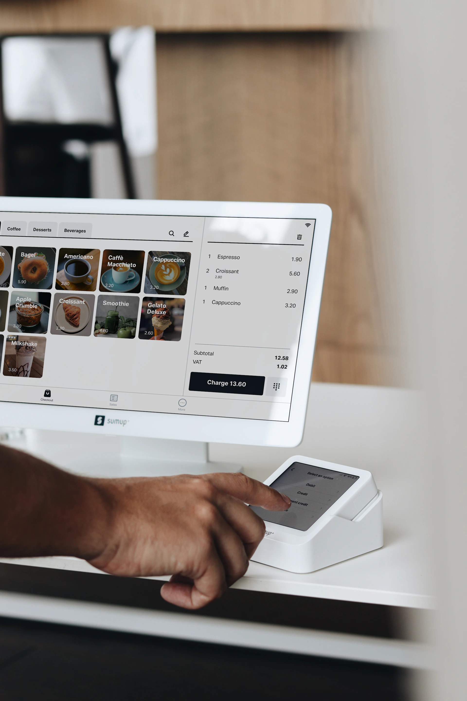 A man holding a cell phone in front of a computer screen