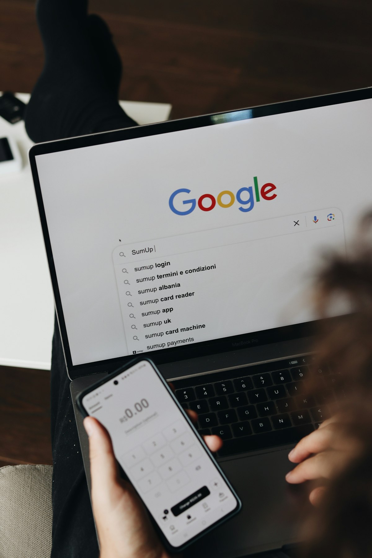 Business owner managing their online presence on laptop and phone