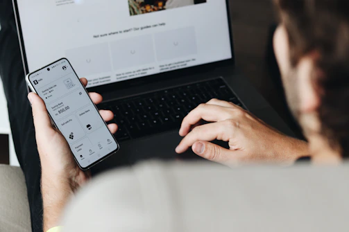 A man sitting on a couch using a laptop computer