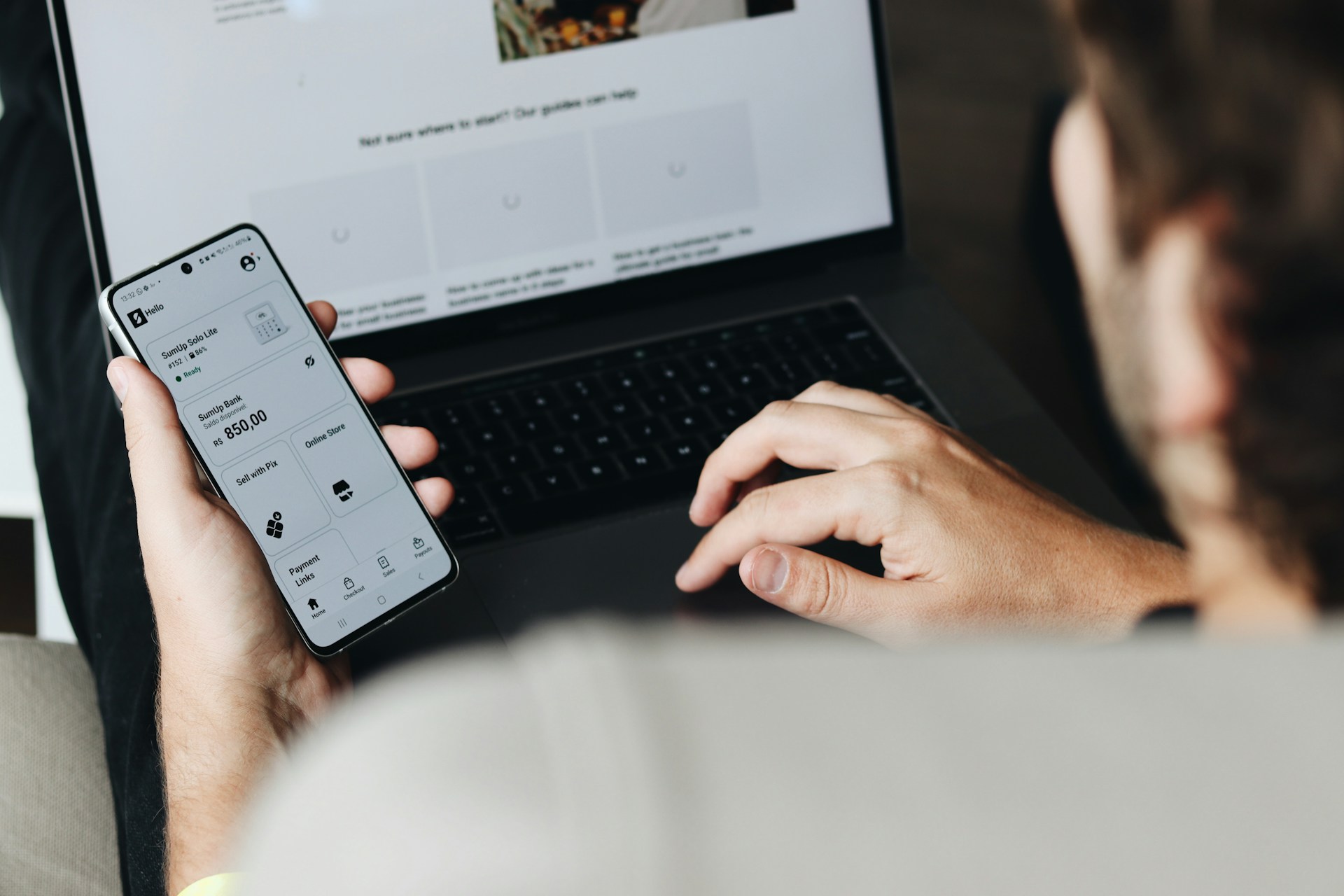 A man sitting on a couch using a laptop computer