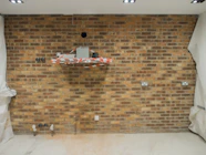 A room with a brick wall and white curtains