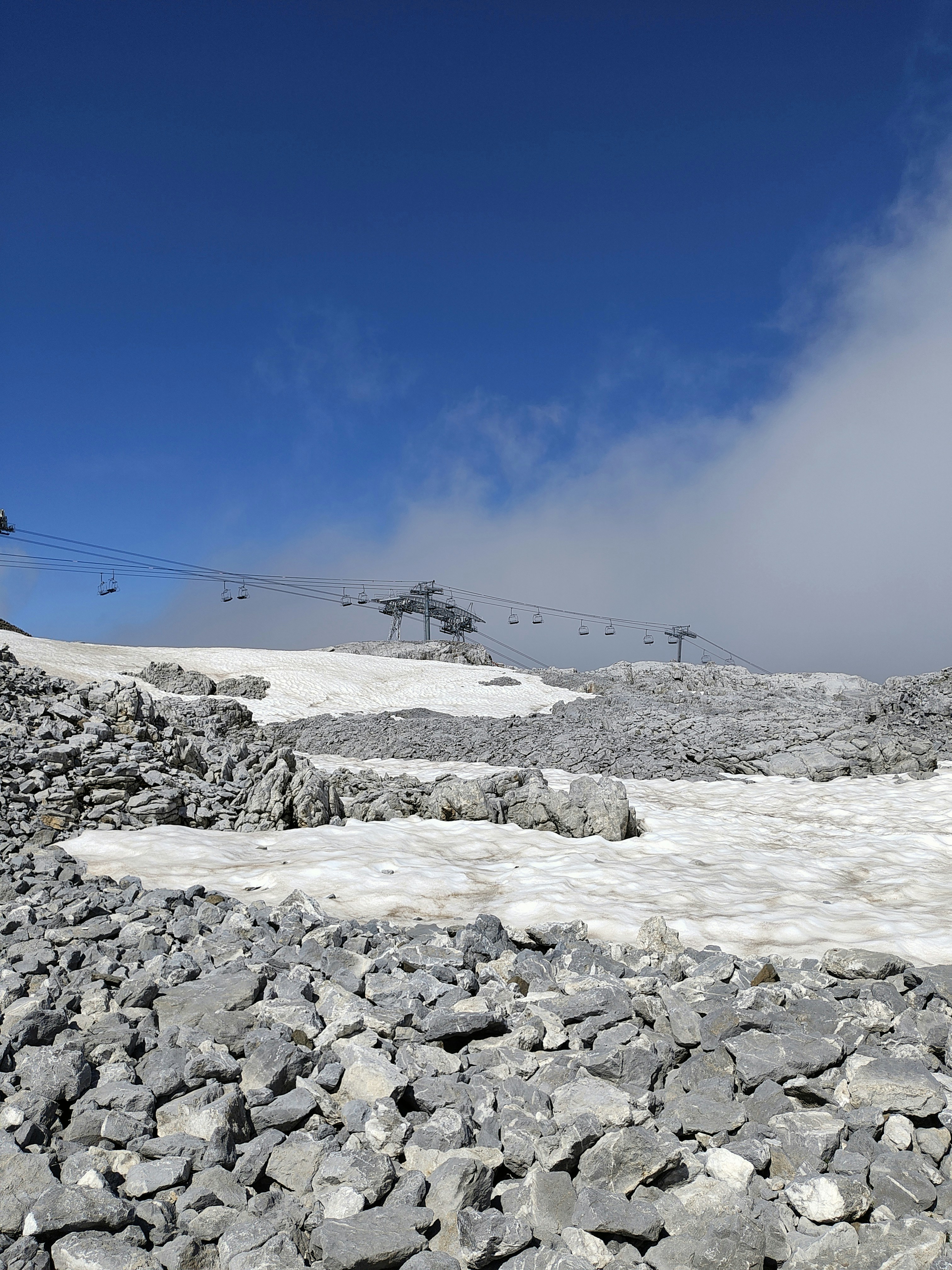 rocky glacier terrain with ski lift cables
