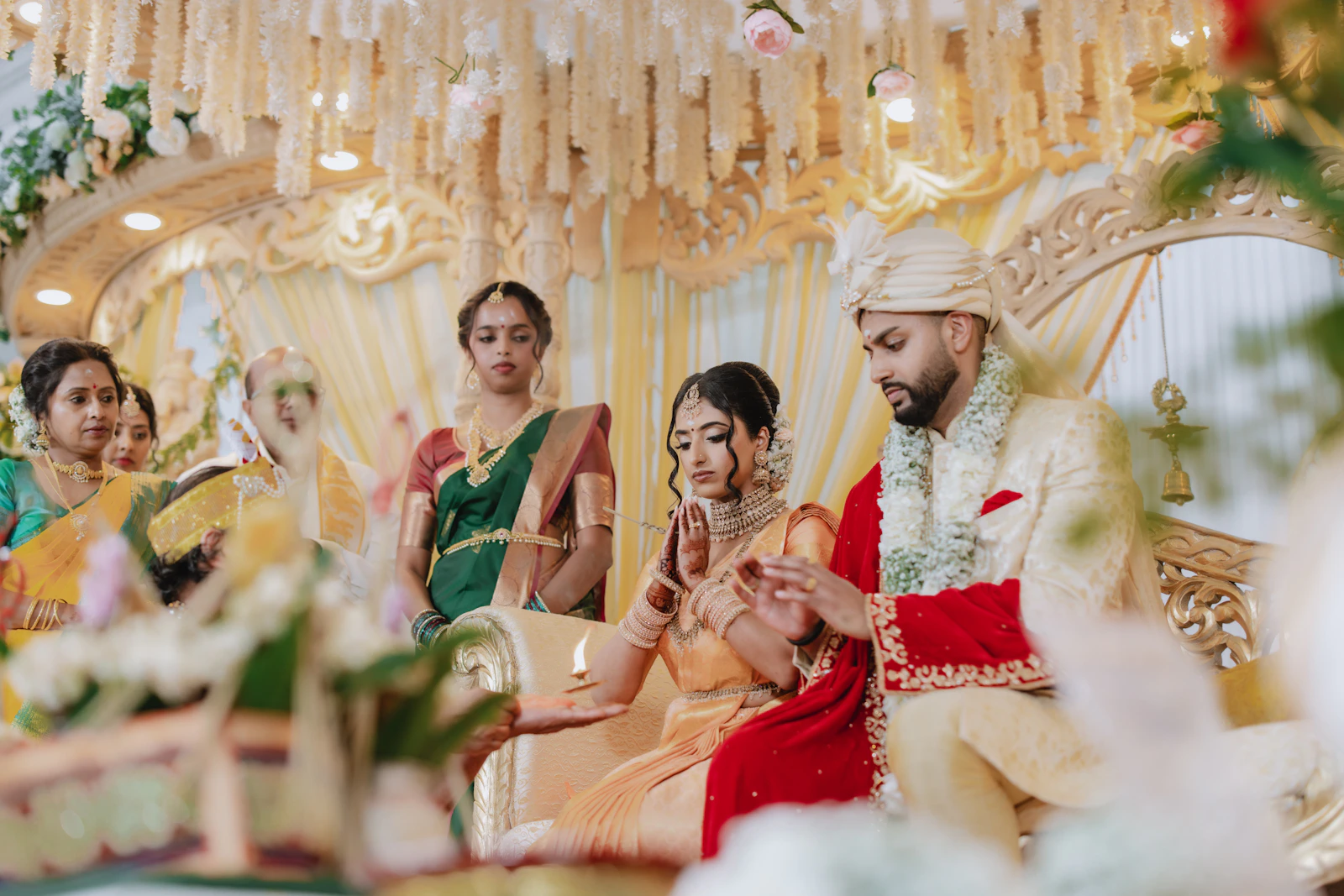 A wedding ceremony under way at a decorated mandap.