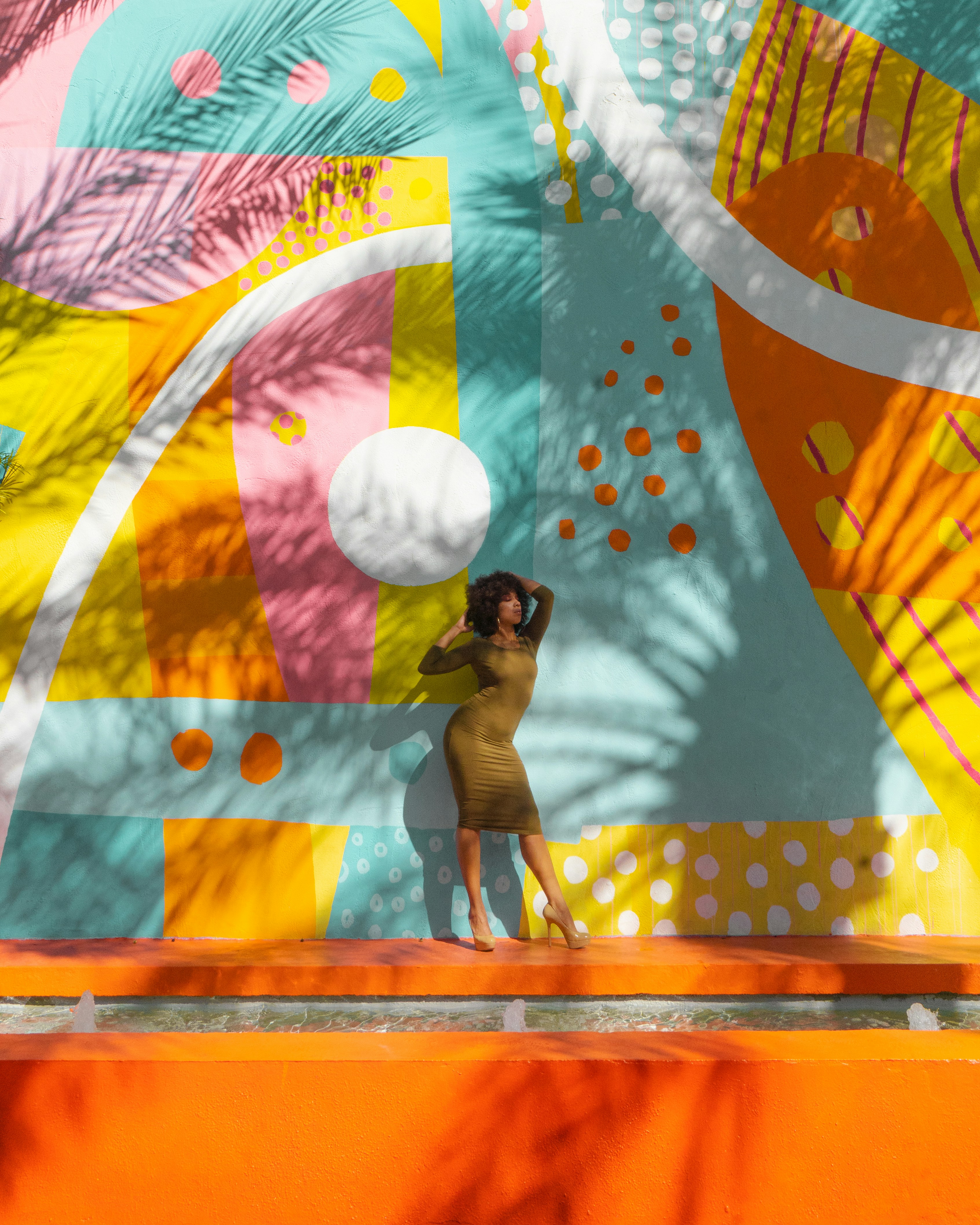 A woman standing in front of a colorful wall