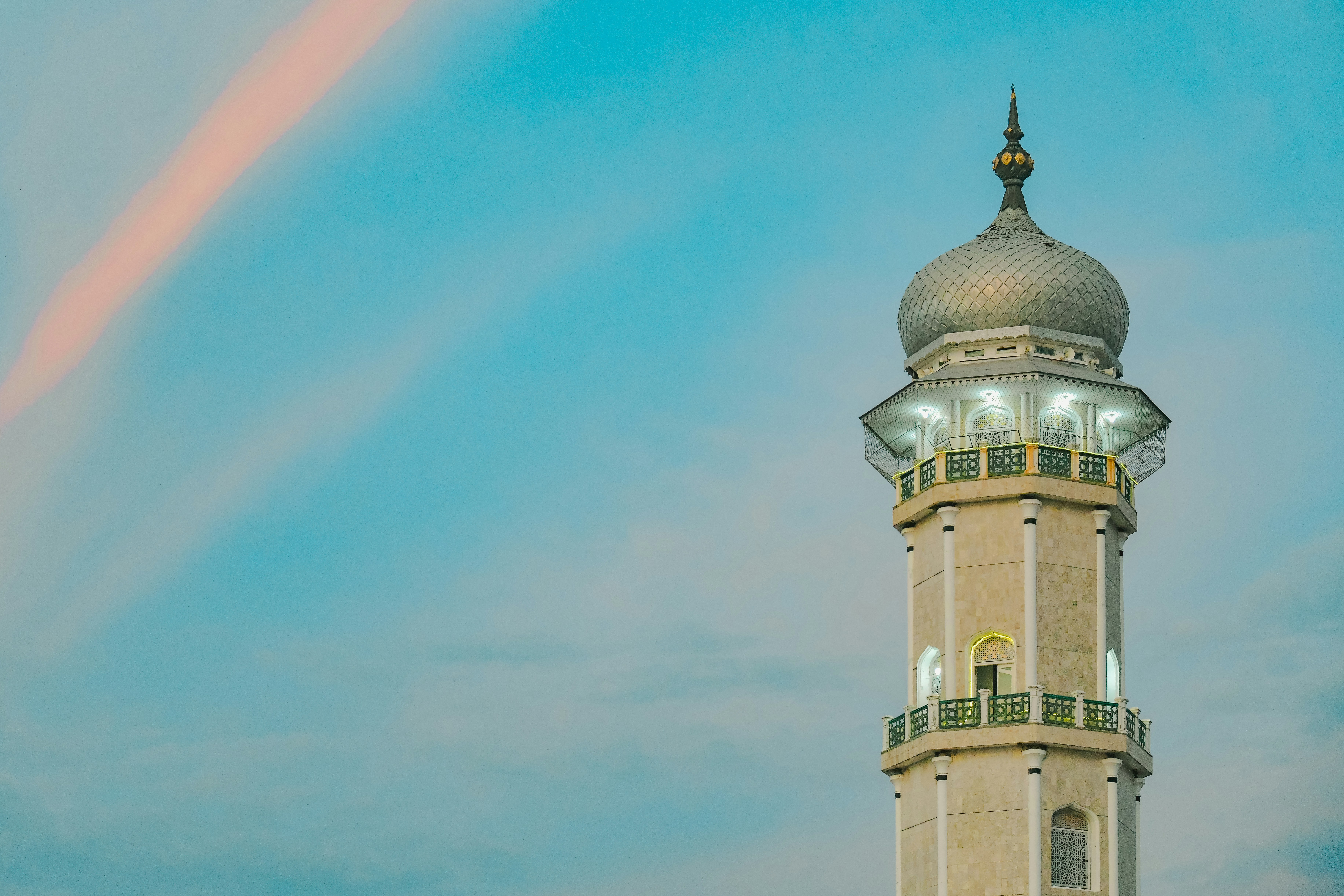 A tall white tower with a sky background