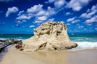 A couple of people walking on a beach next to the ocean