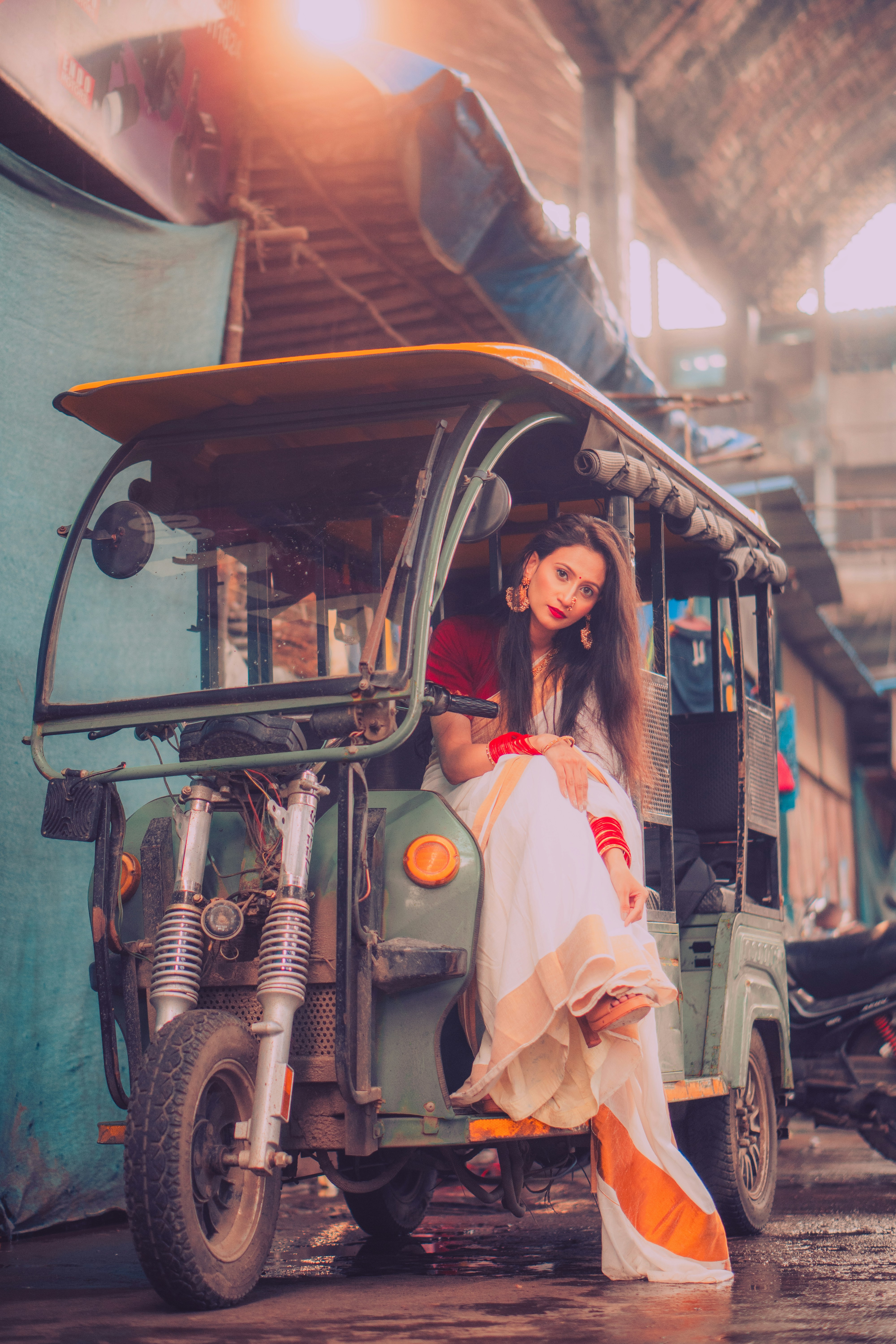A woman sitting on the back of a green vehicle