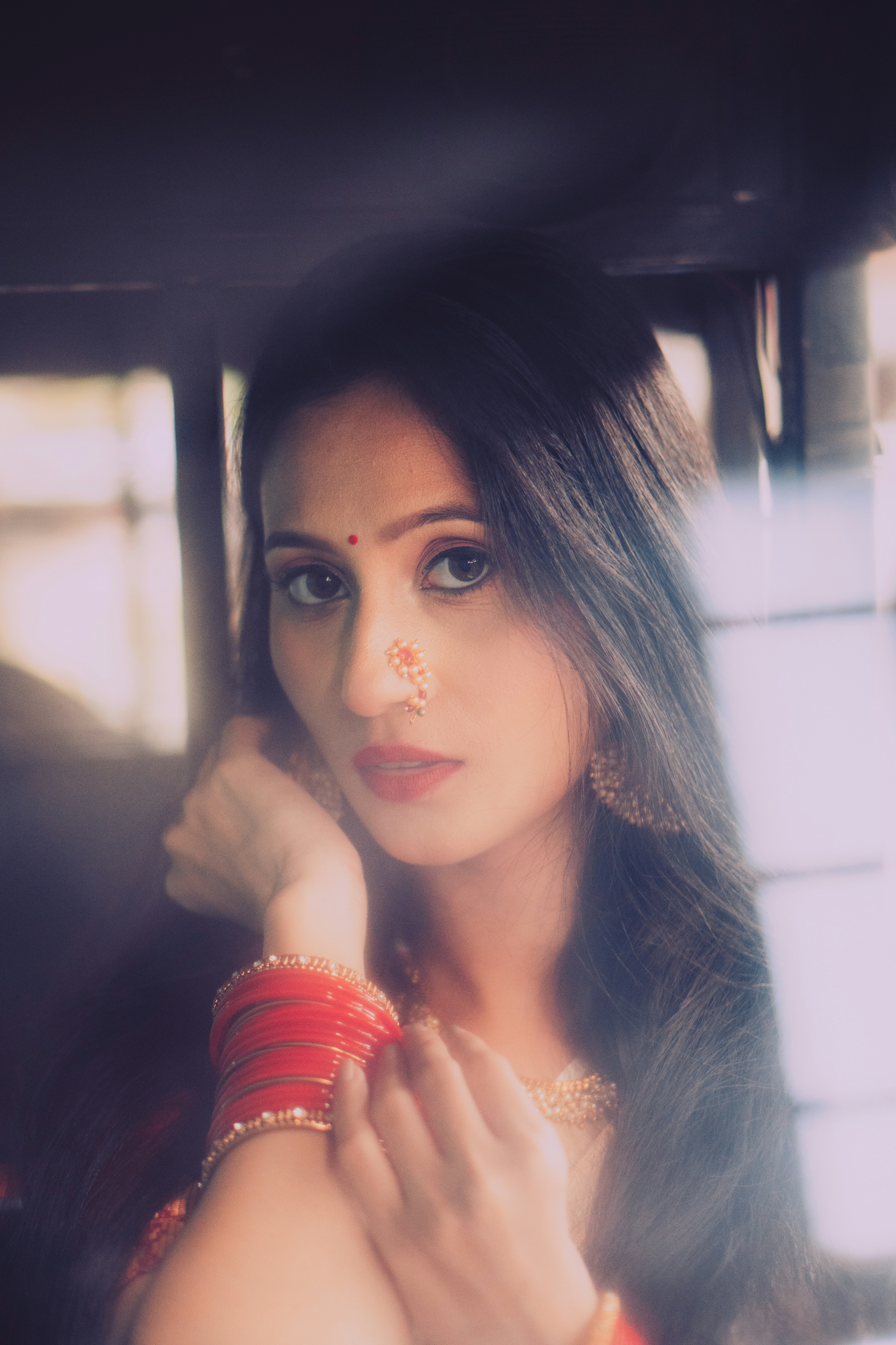 A woman in a red dress holding her hand up to her face