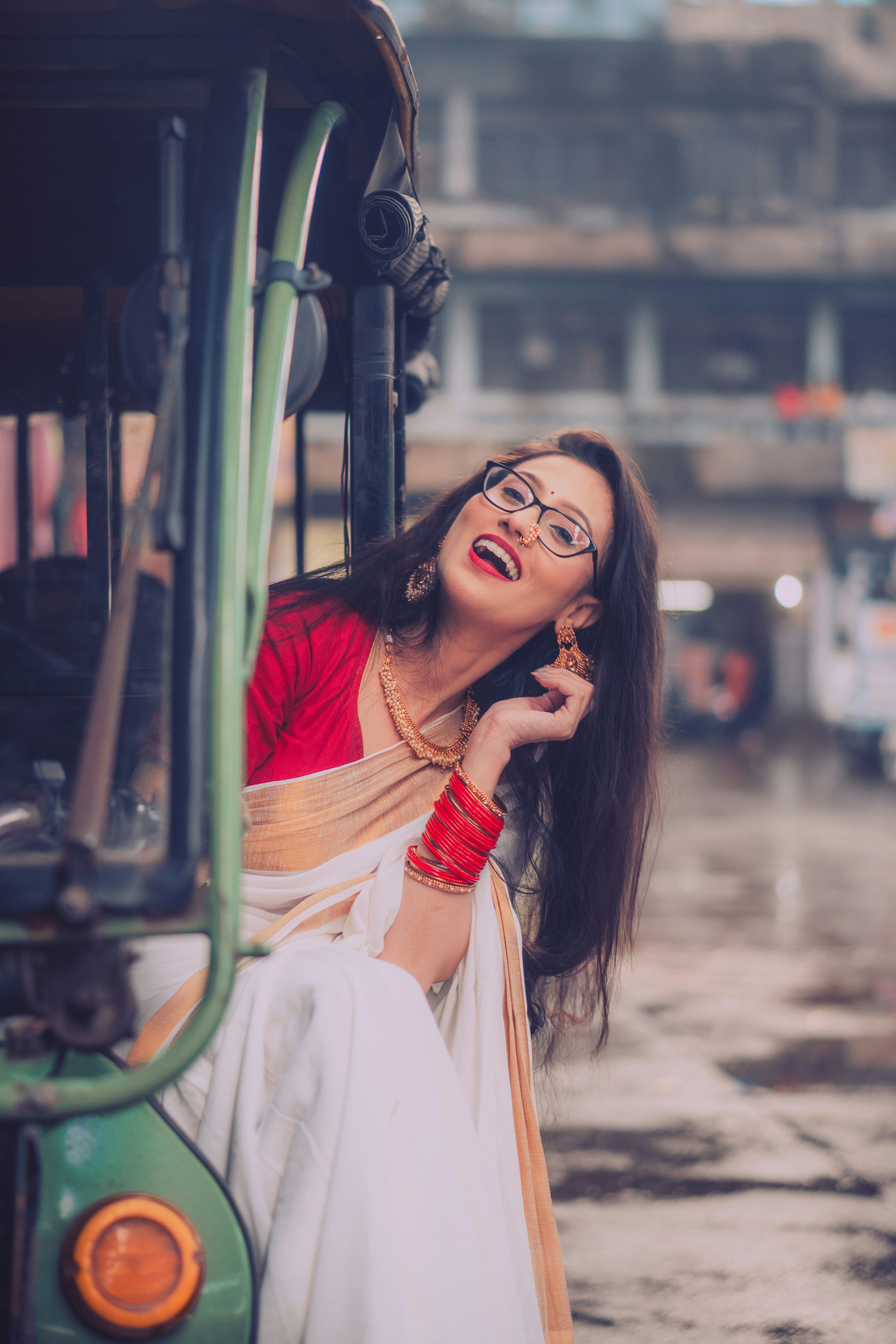 A woman sitting on the back of a bus talking on a cell phone