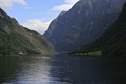 A body of water with mountains in the background