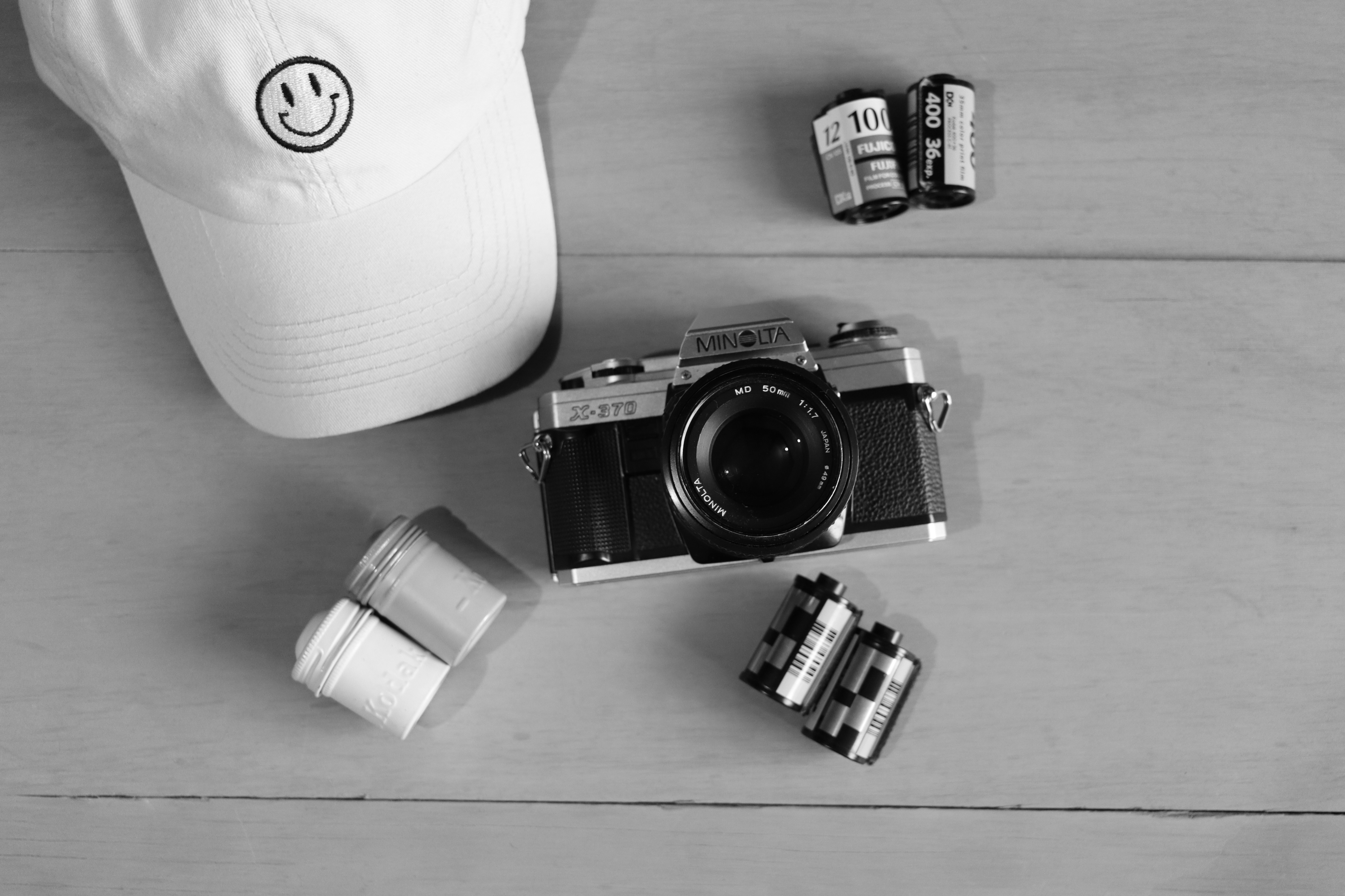 Una foto in bianco e nero di un cappello, una macchina fotografica e altri oggetti