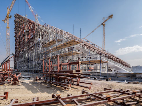 A large building under construction with lots of cranes