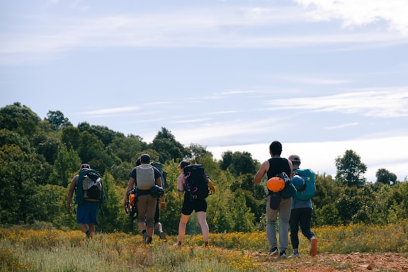 A group of people with backpacks standing in a field