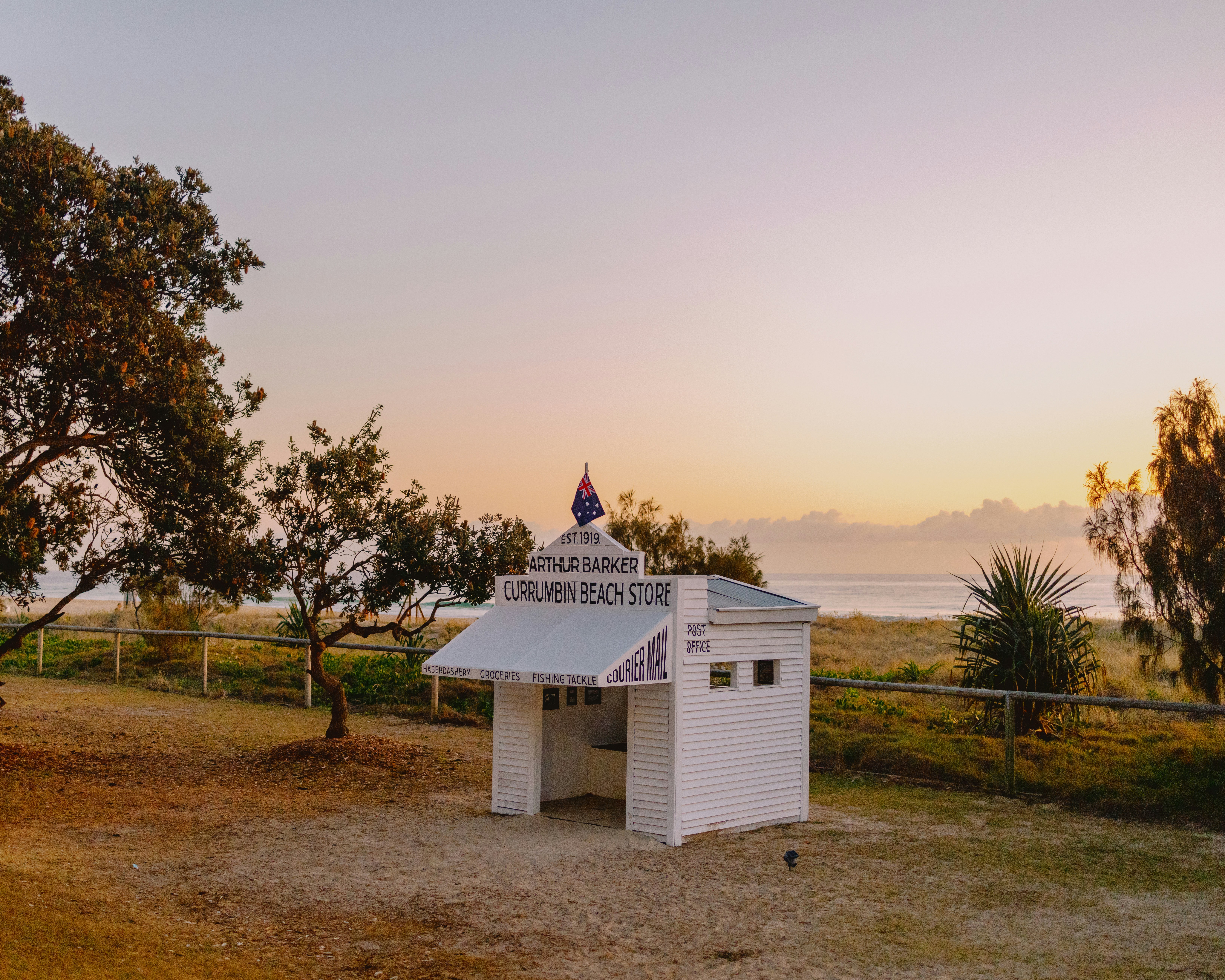 A small white building sitting in the middle of a field