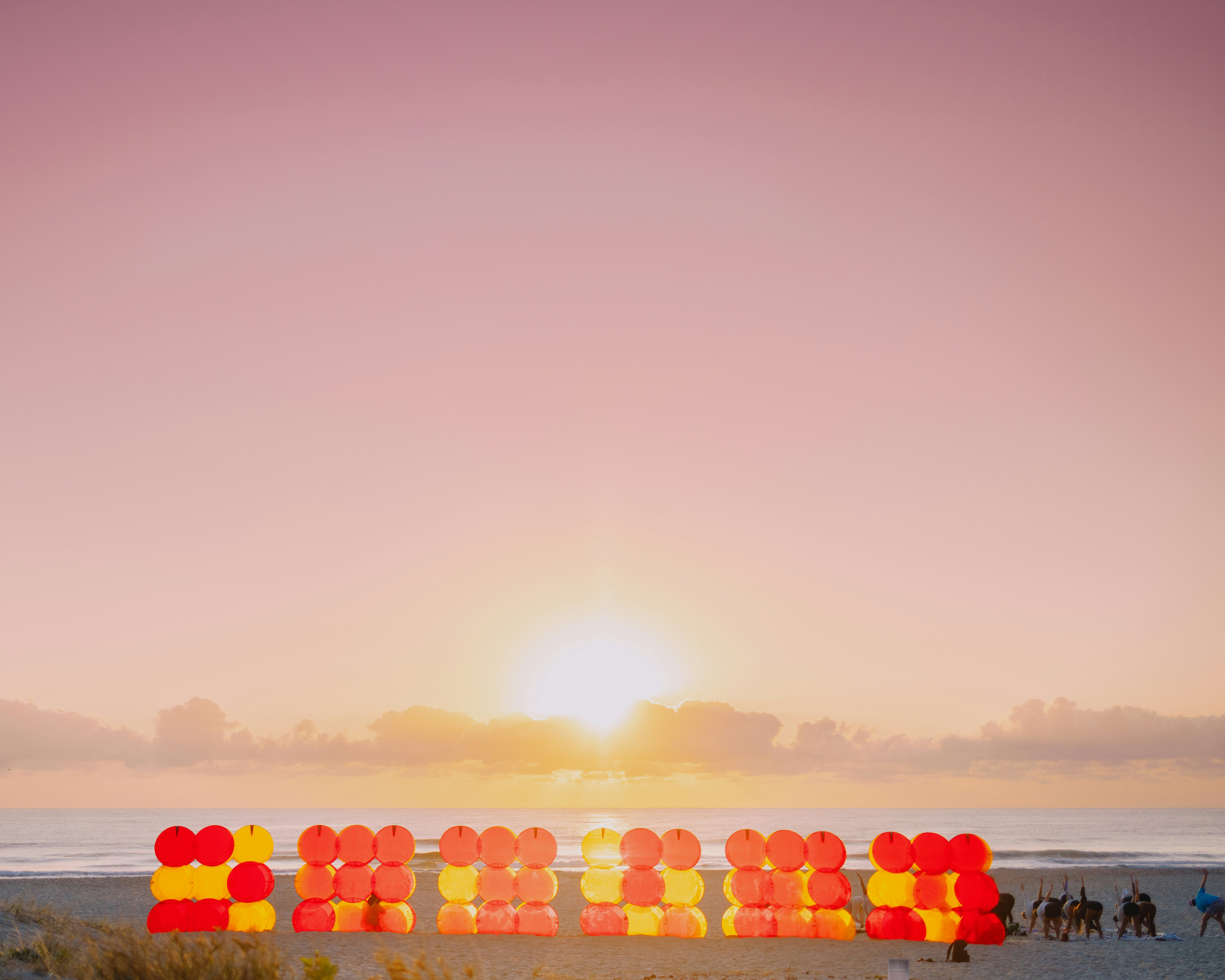 A group of people standing on top of a sandy beach