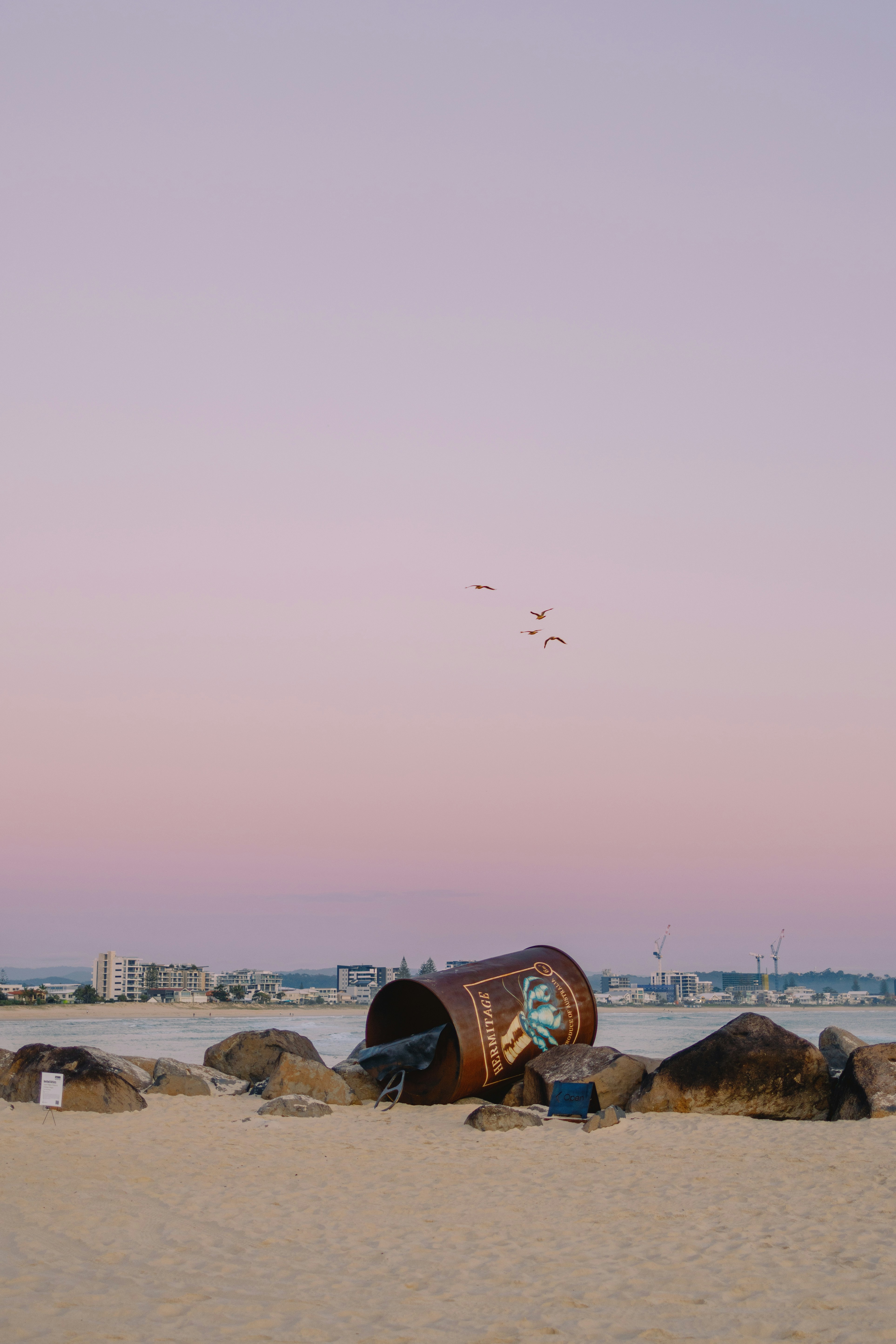 A barrel sitting on top of a sandy beach