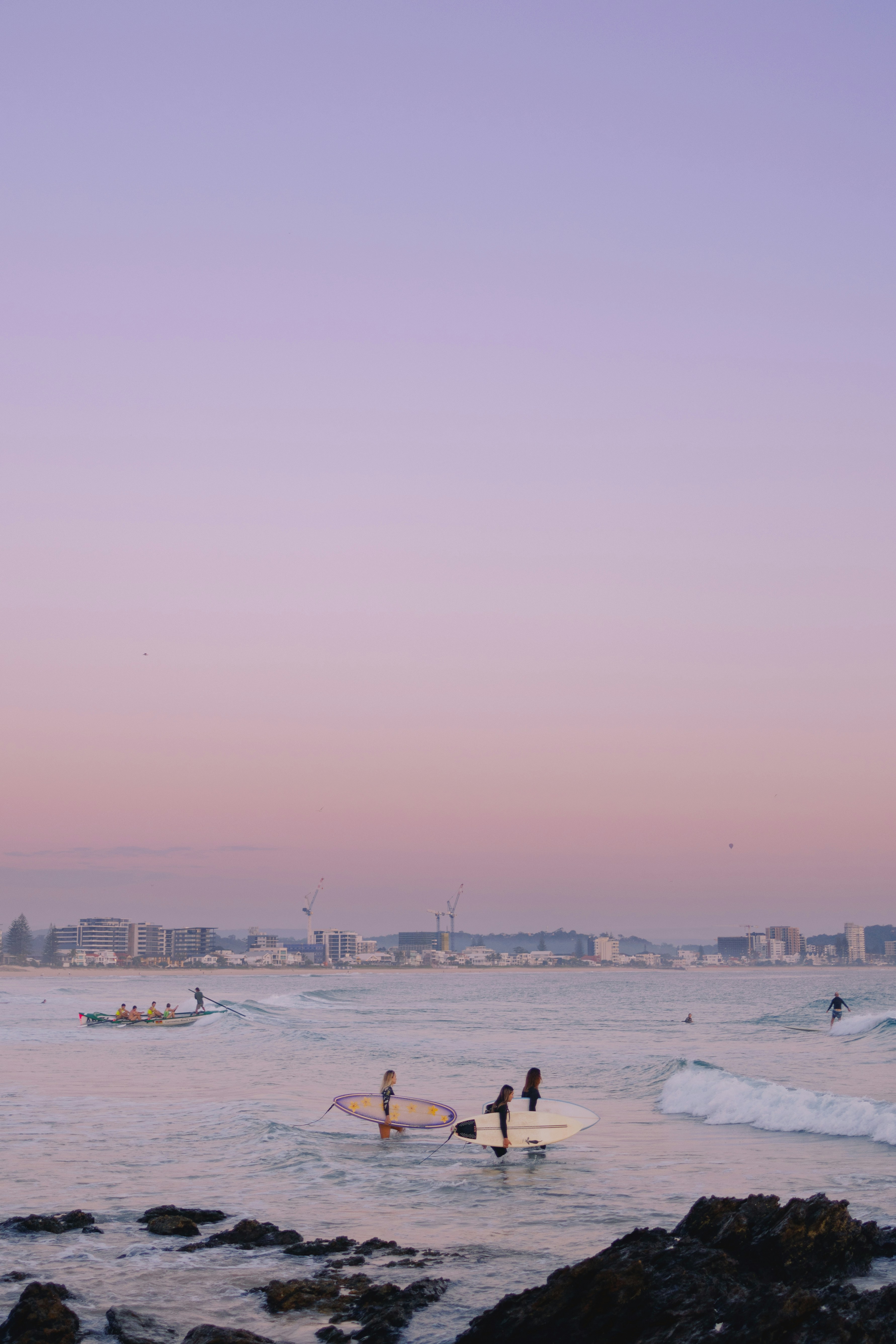 A group of people standing on top of a beach next to the ocean