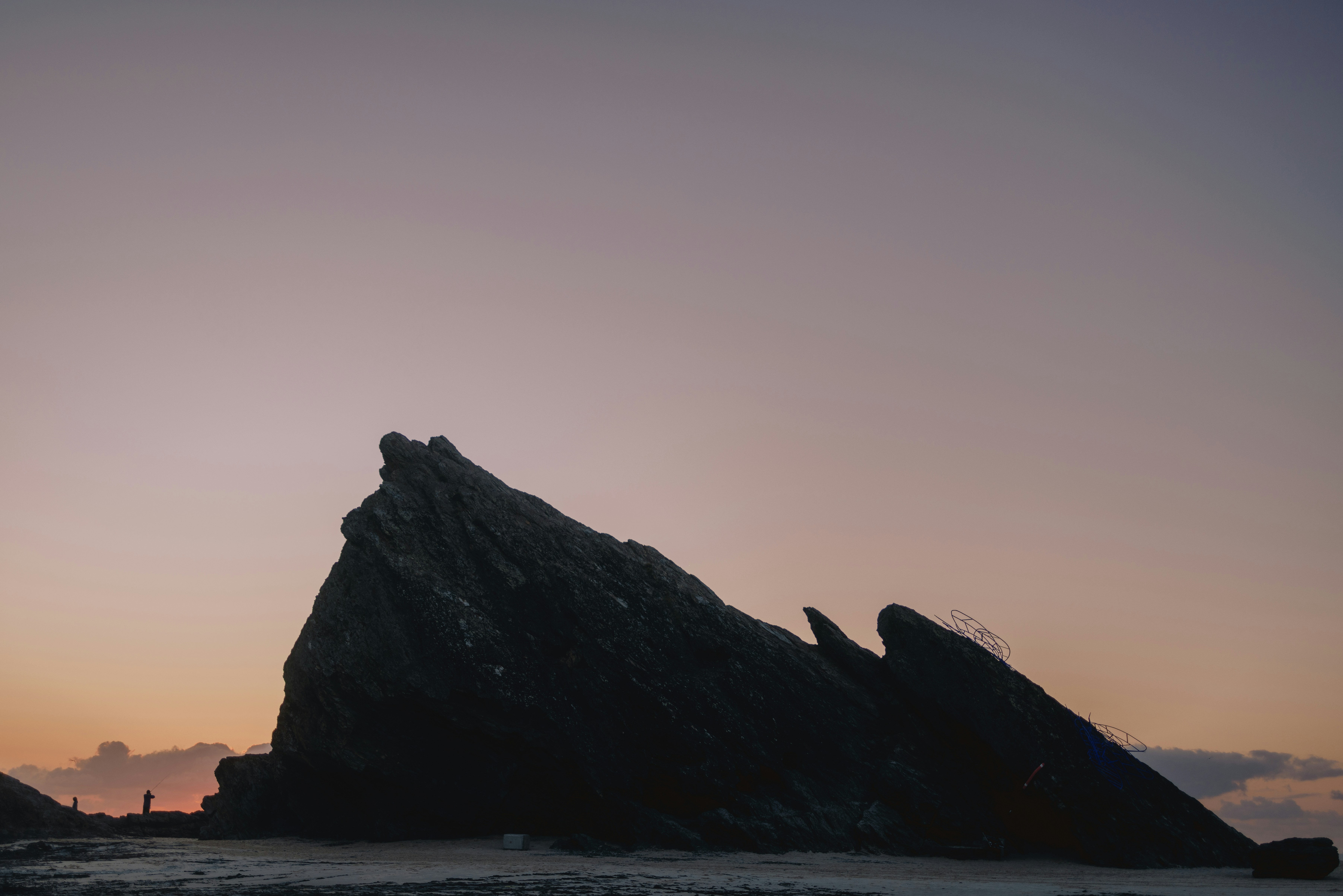 A large rock sitting on top of a sandy beach