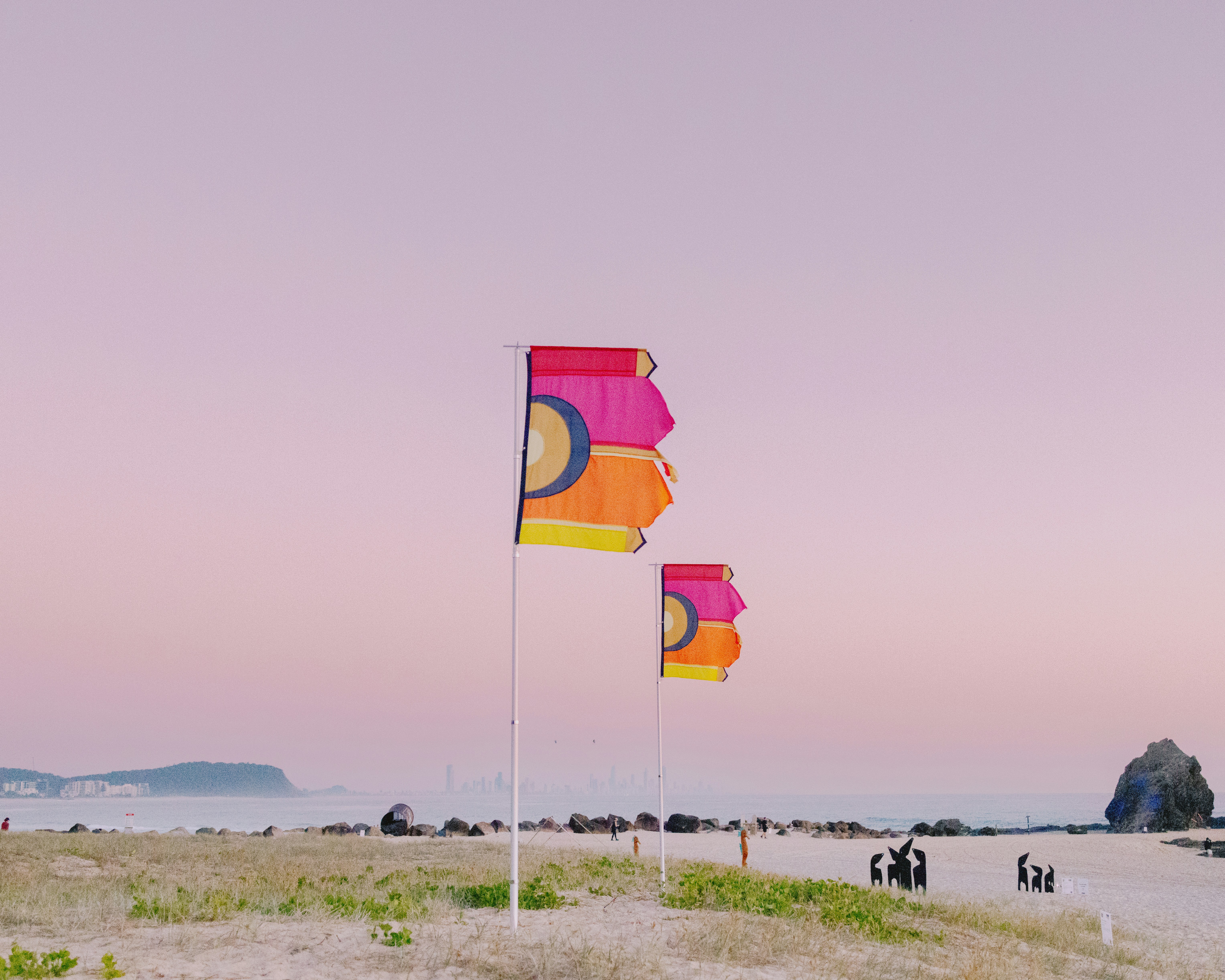 A group of people standing on top of a sandy beach