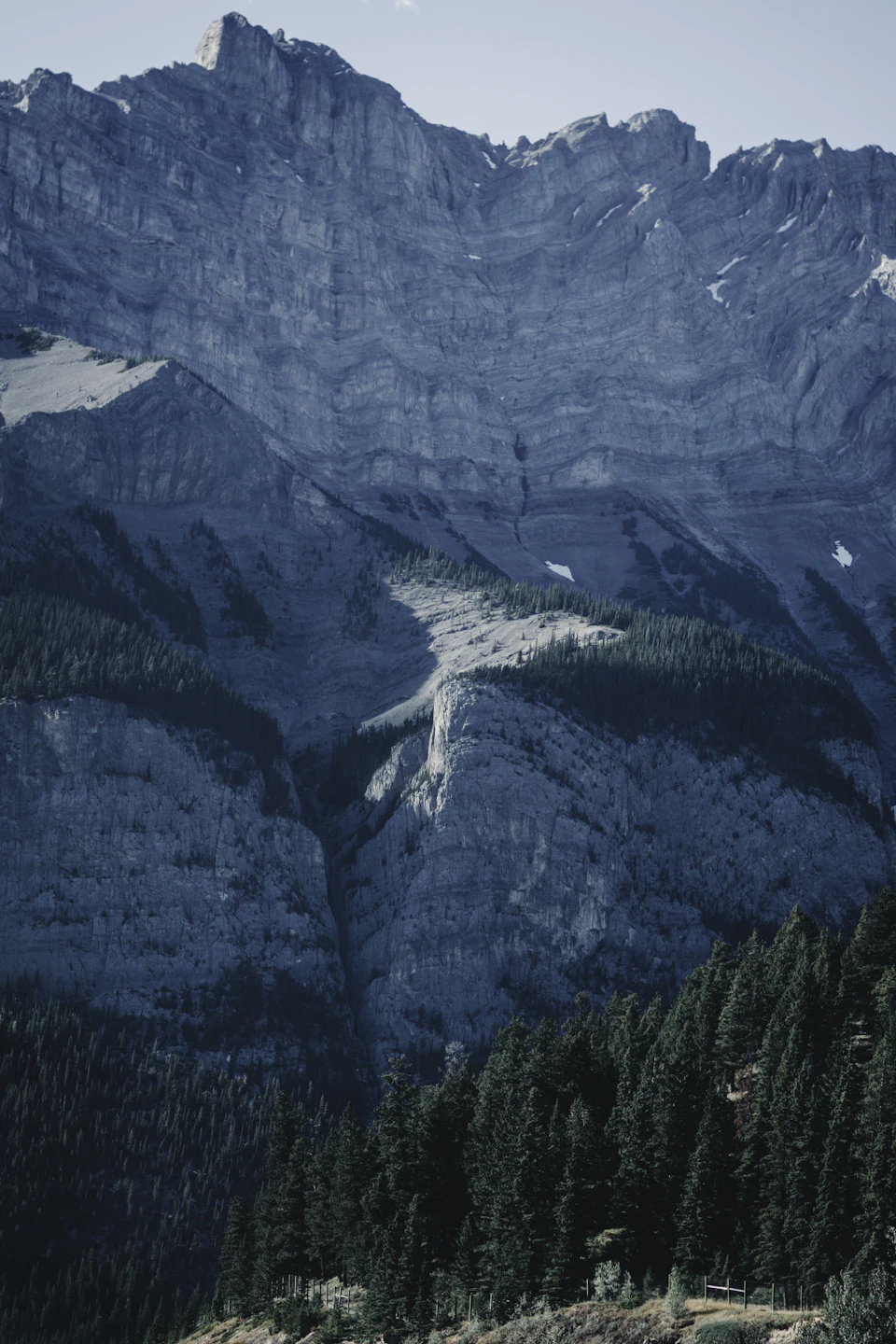 Mountain range with snow-covered peaks and surrounding trees in a serene landscape setting