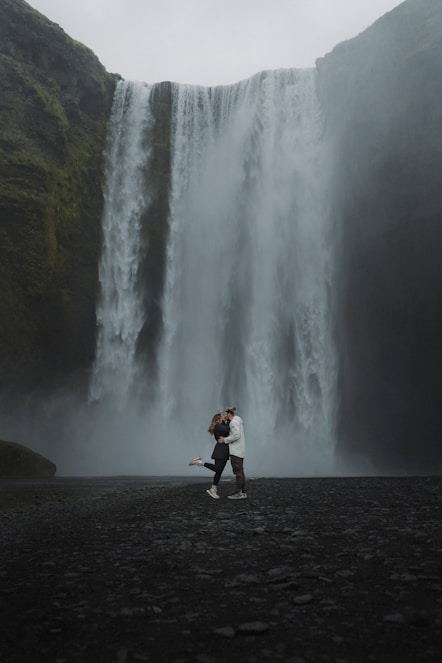 A man standing in front of a waterfall