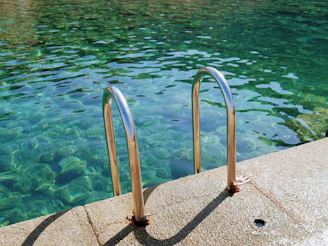 A swimming pool with a metal railing next to it