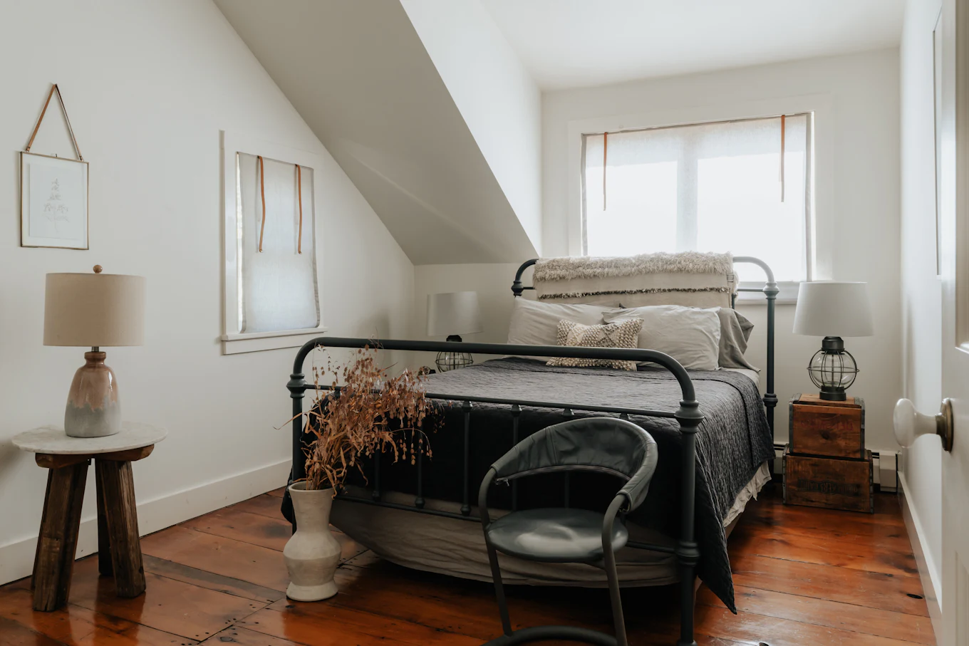 The bedroom, an iron bed made up in linen under the slope of the roof