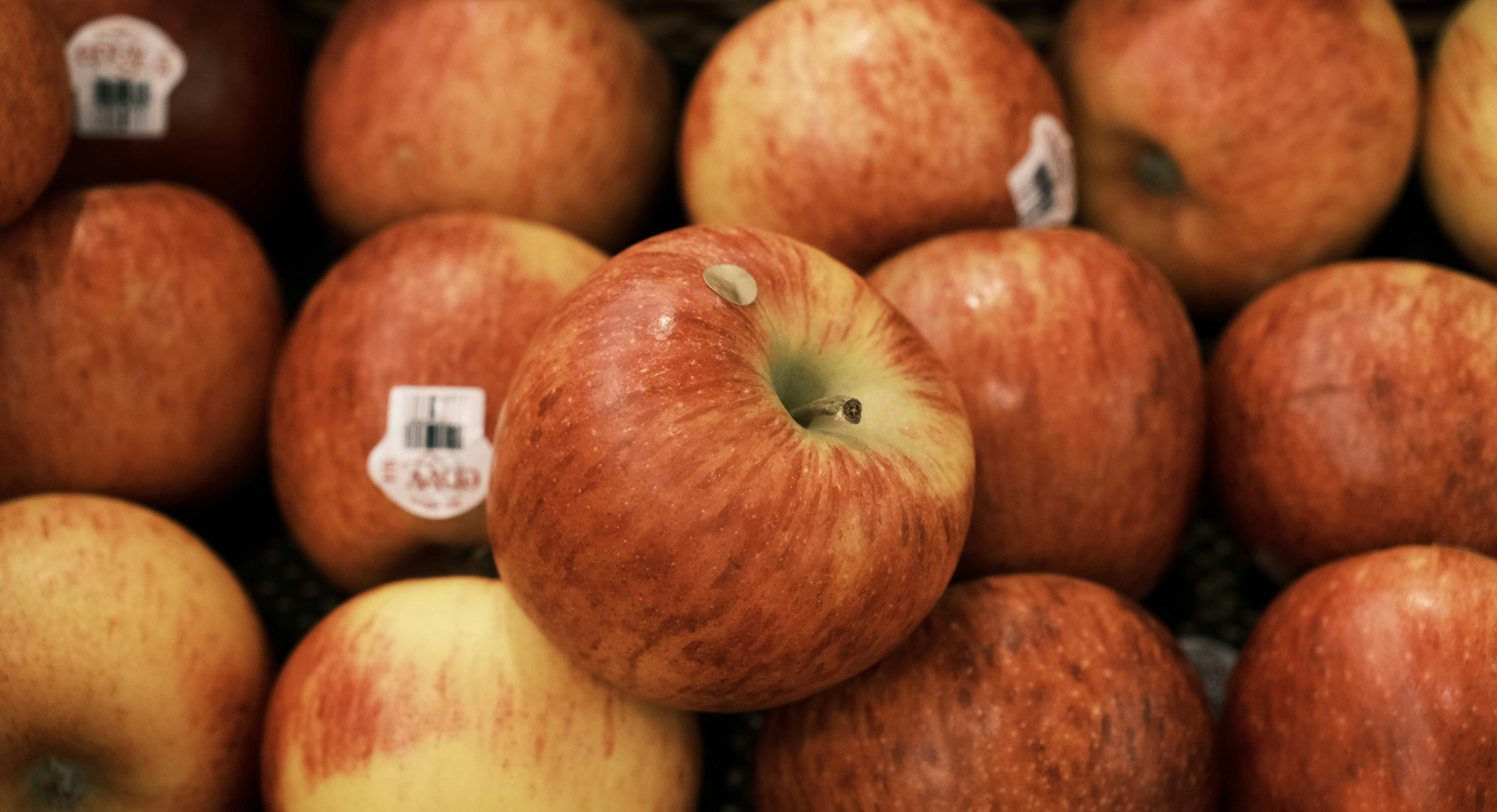 A pile of red and yellow apples sitting on top of each other