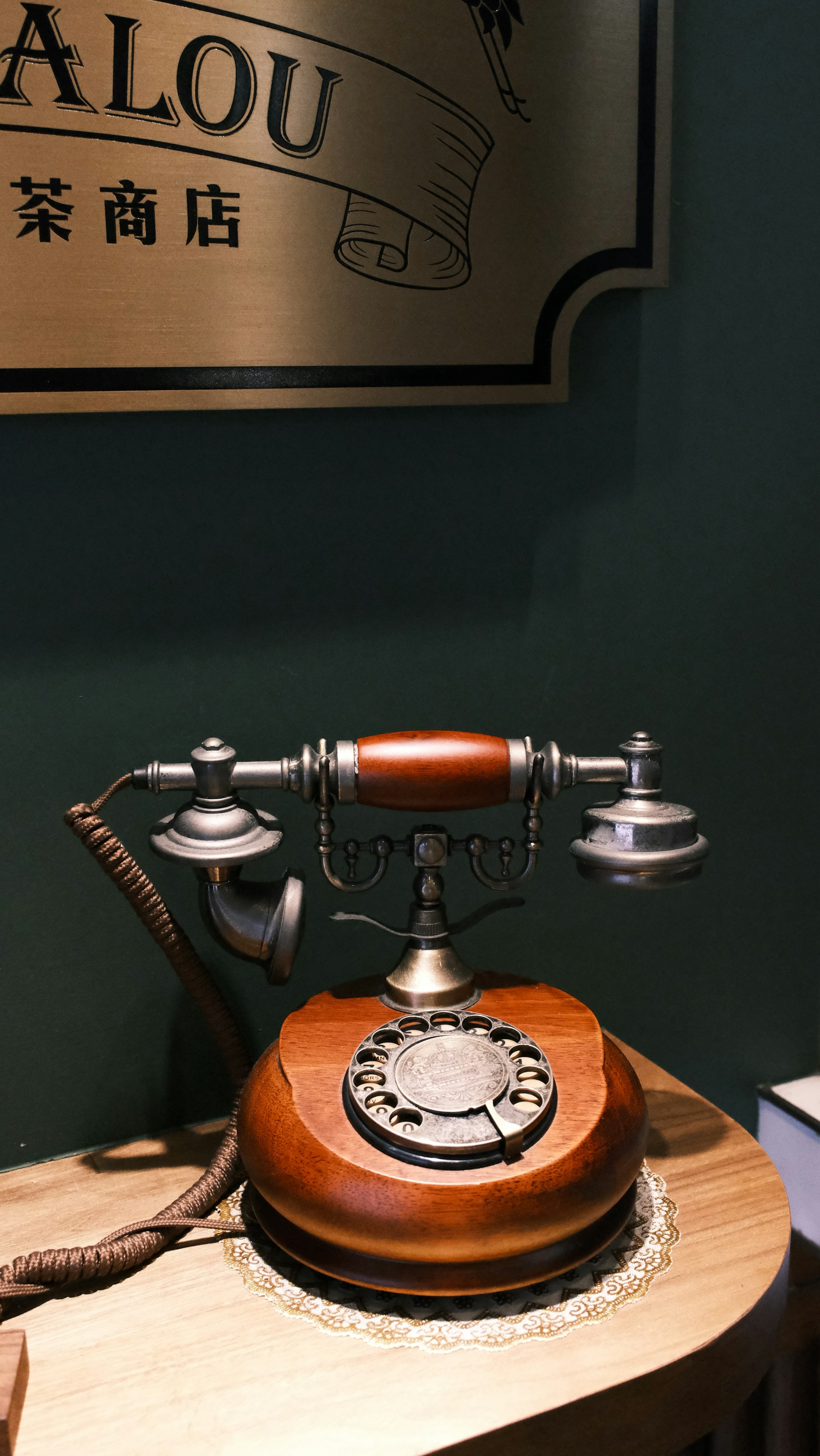 An old fashioned phone sitting on top of a wooden table