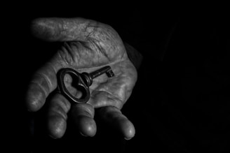 A person's hand holding a key in the dark
