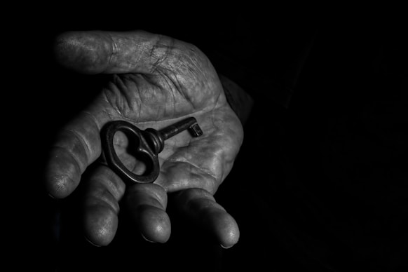 A person's hand holding a key in the dark