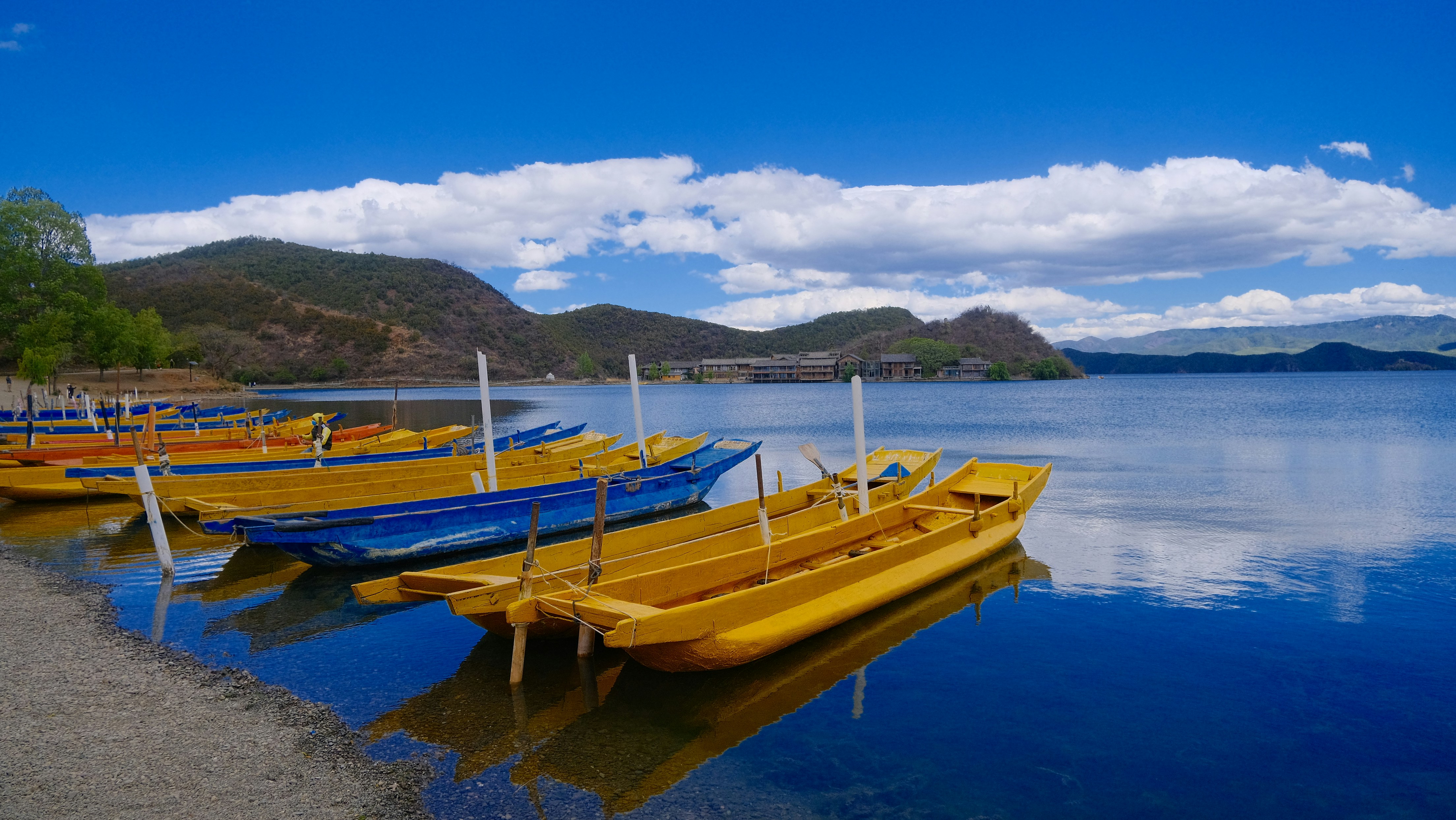 A row of yellow boats sitting on top of a lake