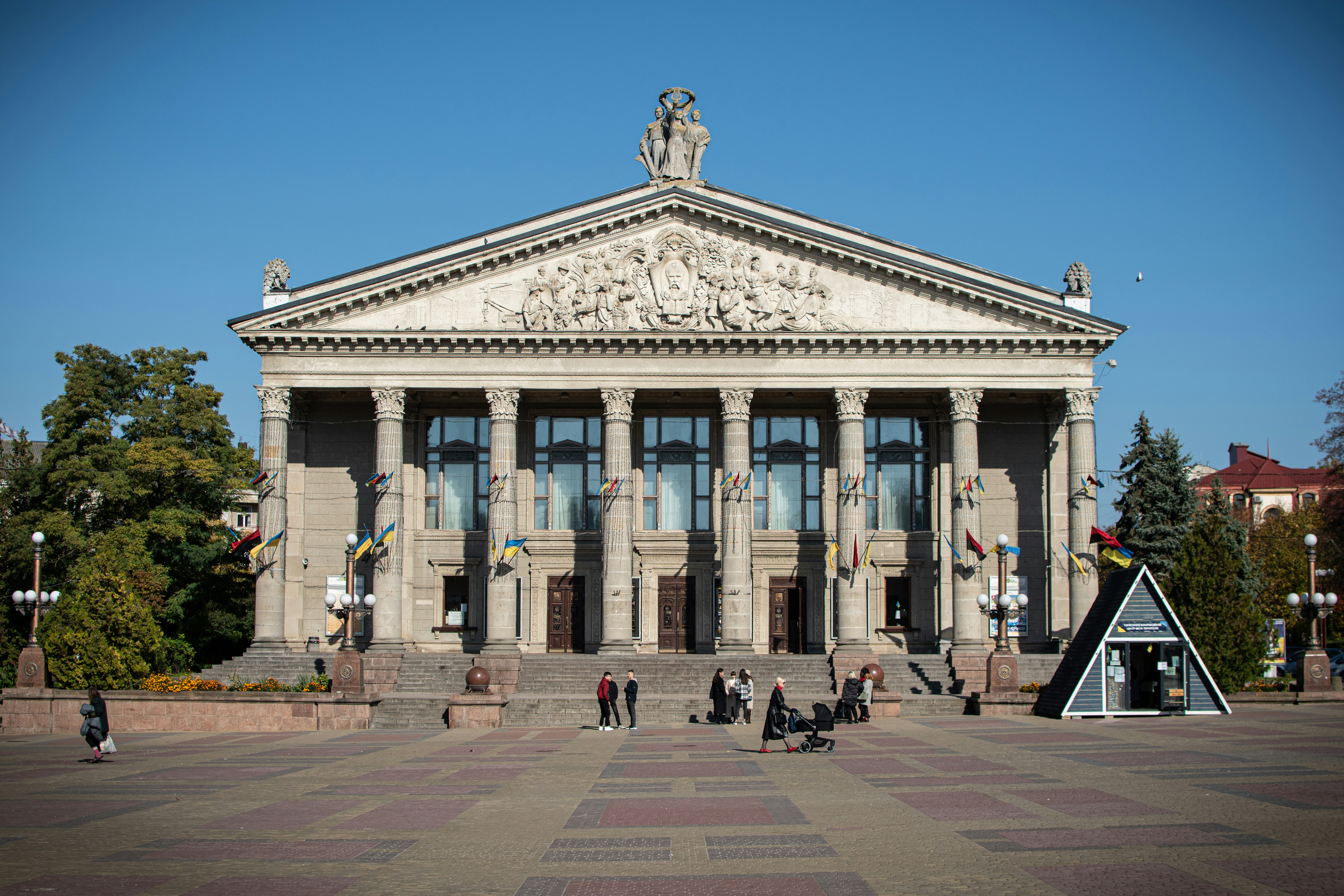 A large building with a lot of windows and people walking around it