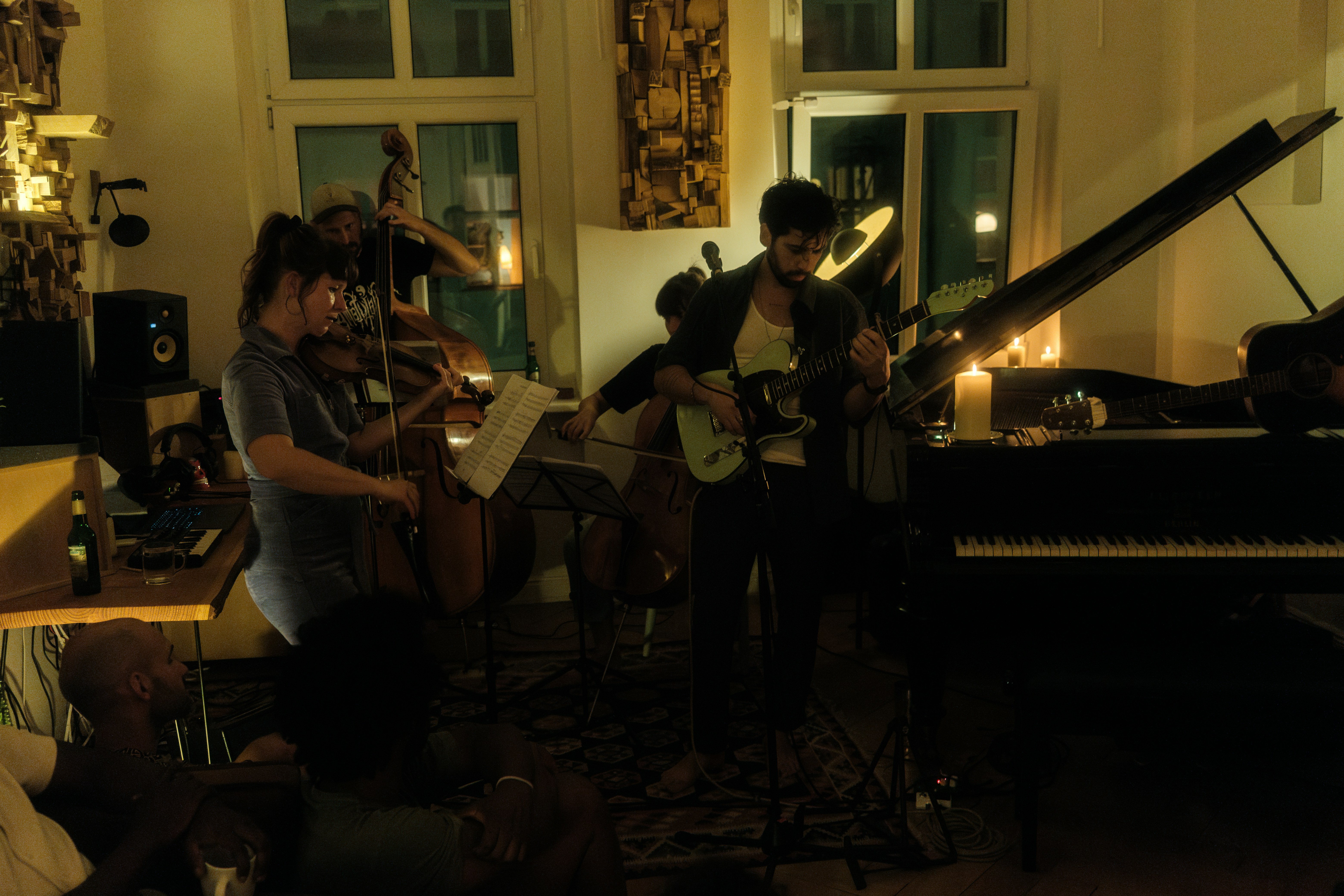A group of people playing instruments in a living room